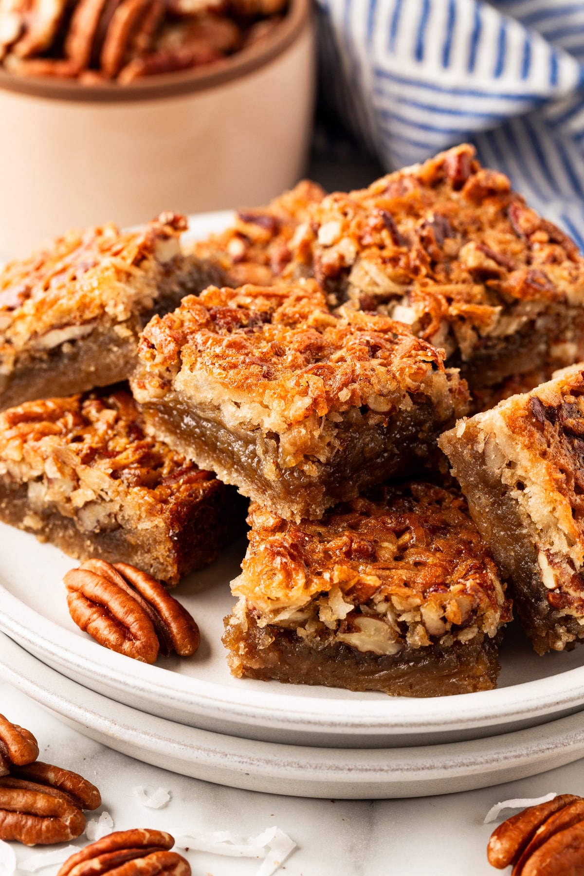 Chewy Pecan Bars stacked on each other on a plate. 