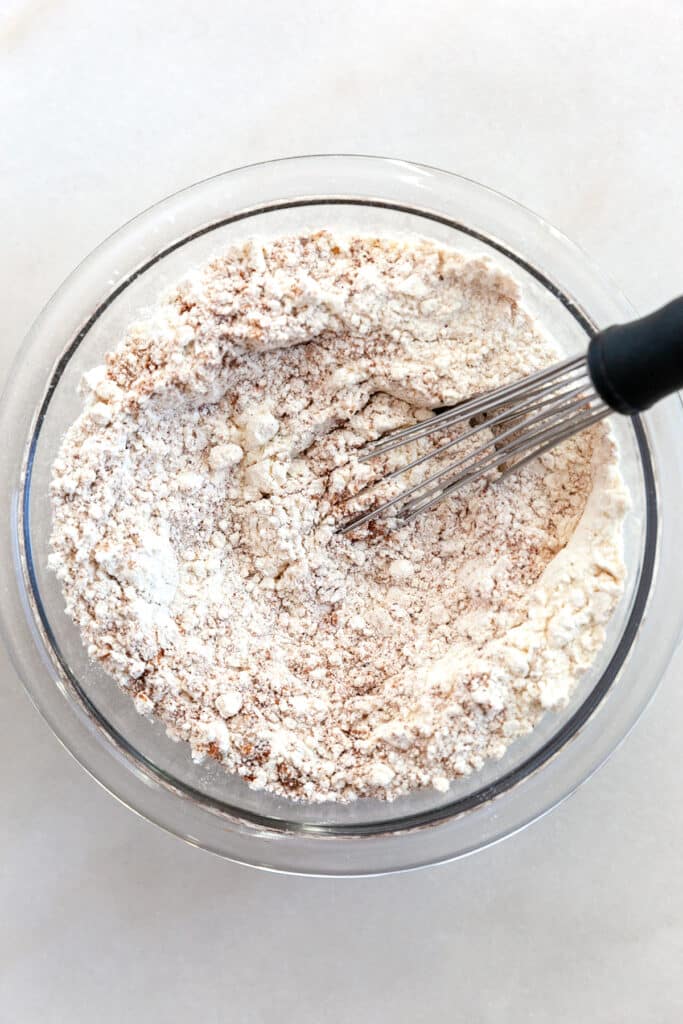 Dry ingredients with a whisk in a bowl. 