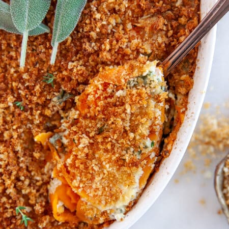 Sweet Potato Au Gratin, taking a scoop from a casserole.