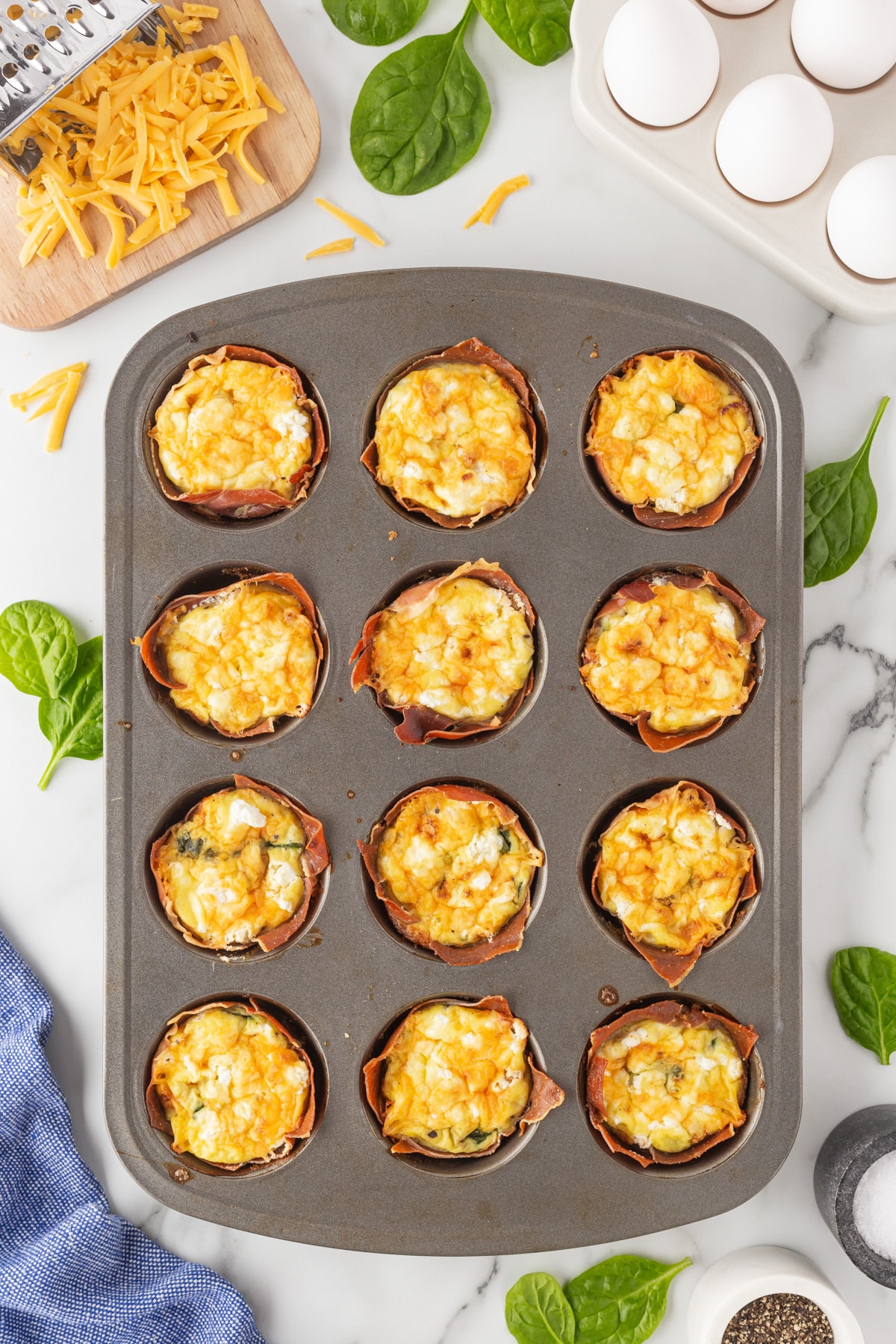 Overhead of baked ham and egg cups in a muffin pan. 