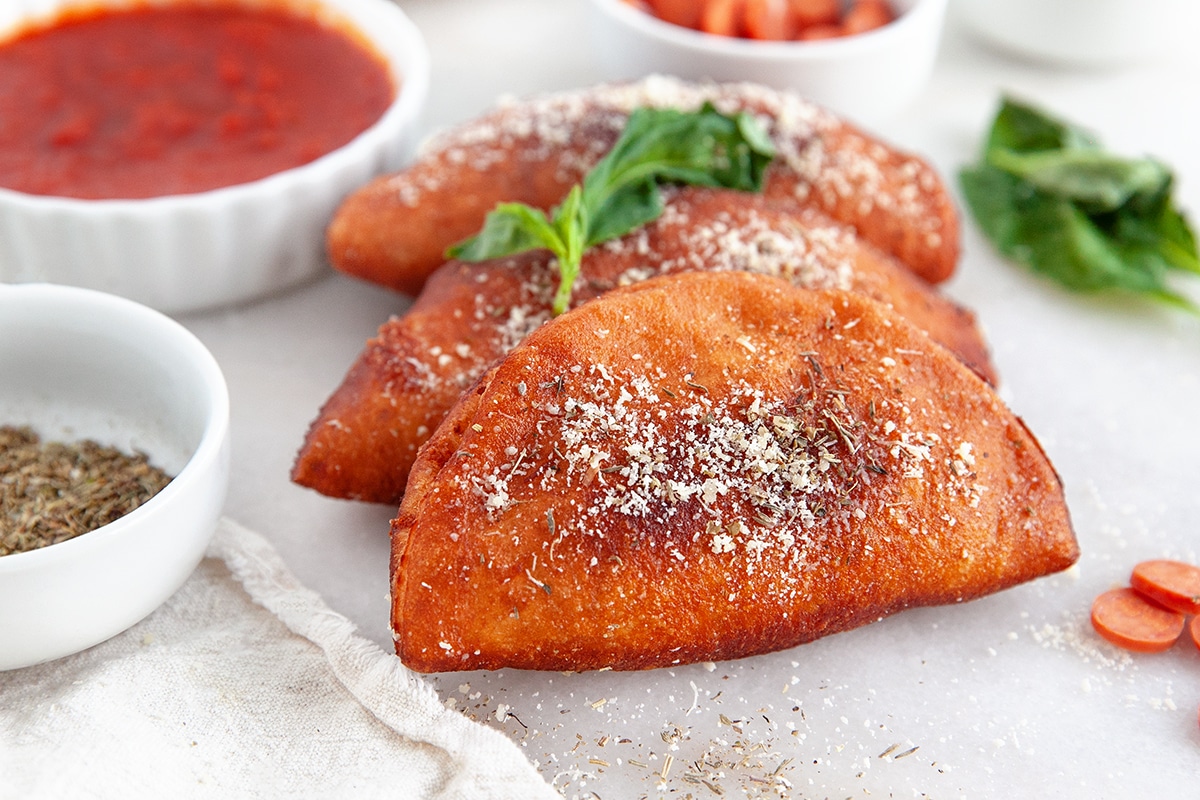 Panzerotti on a plate with marinara in the background. 