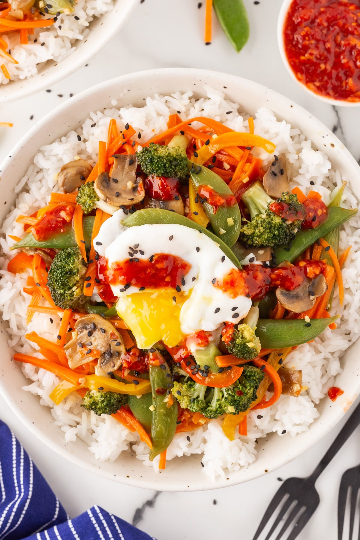 Overhead shot of Vegetarian Stir-Fry with Eggs, in particular a poached egg. 