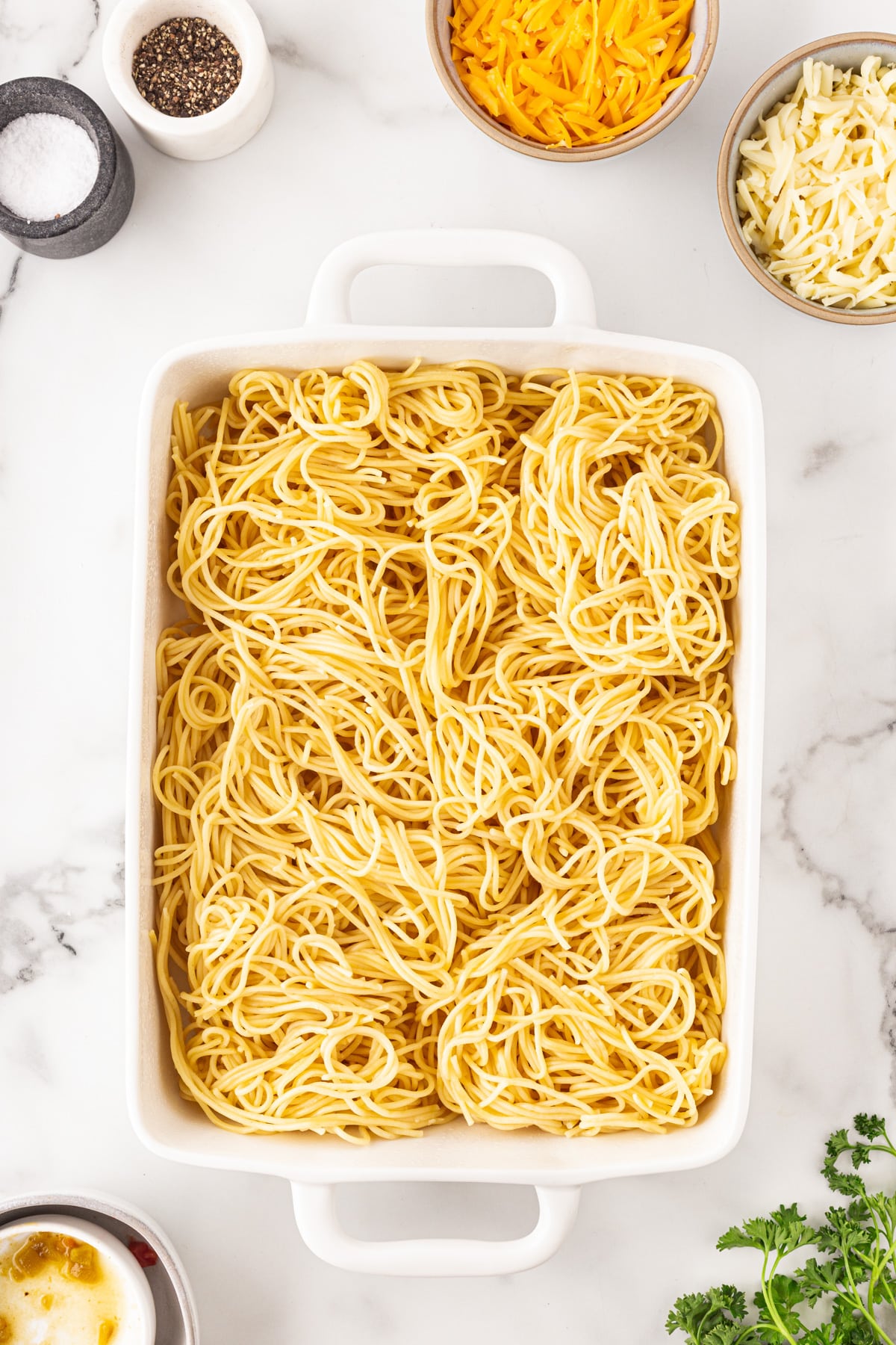 Spaghetti added to a casserole dish. 