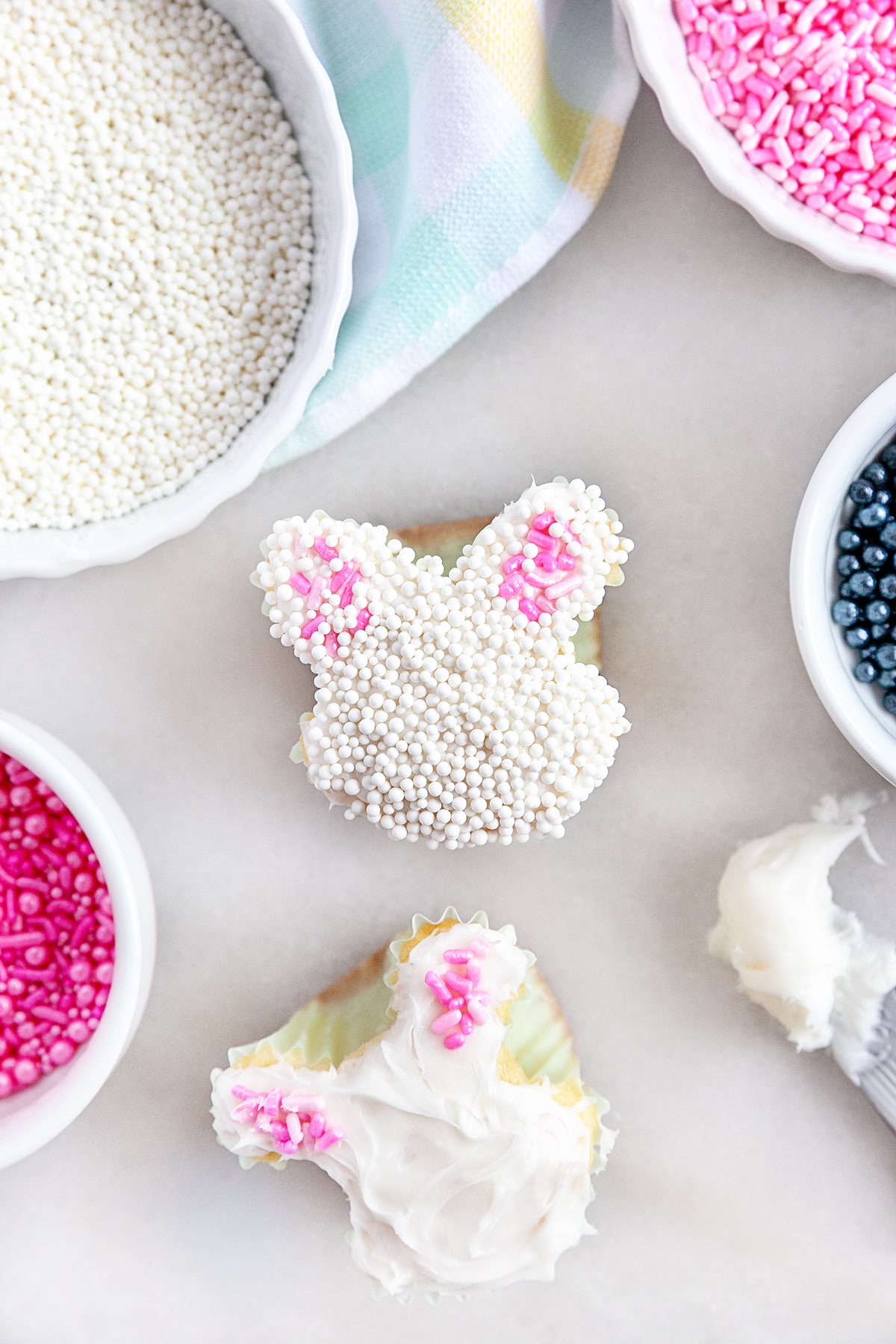 Adding icing and sprinkles to the cupcakes. 