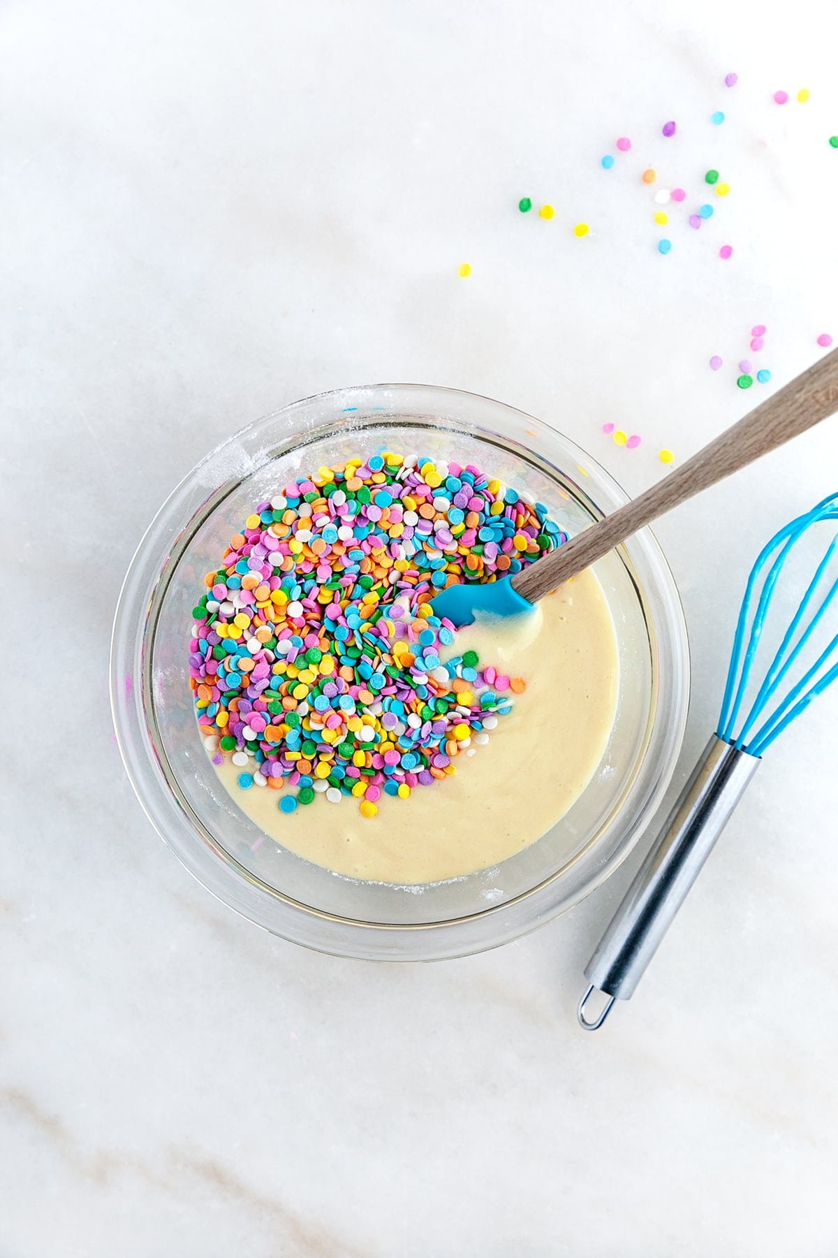 Adding confetti sprinkles to the batter. 