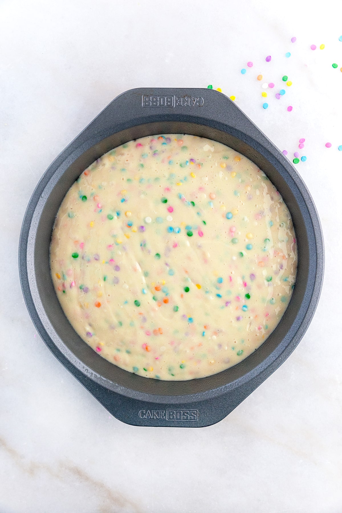 Cake batter in a round pan ready for the oven. 