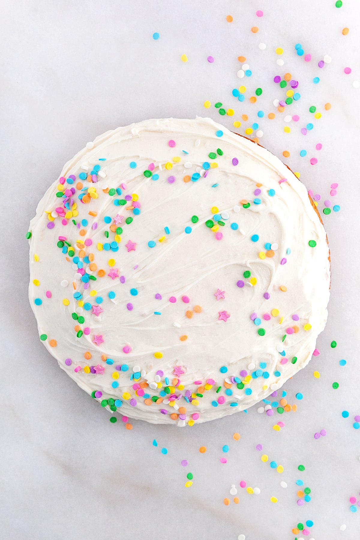 Round Funfetti Cake Iced and confetti sprinkles on top. 