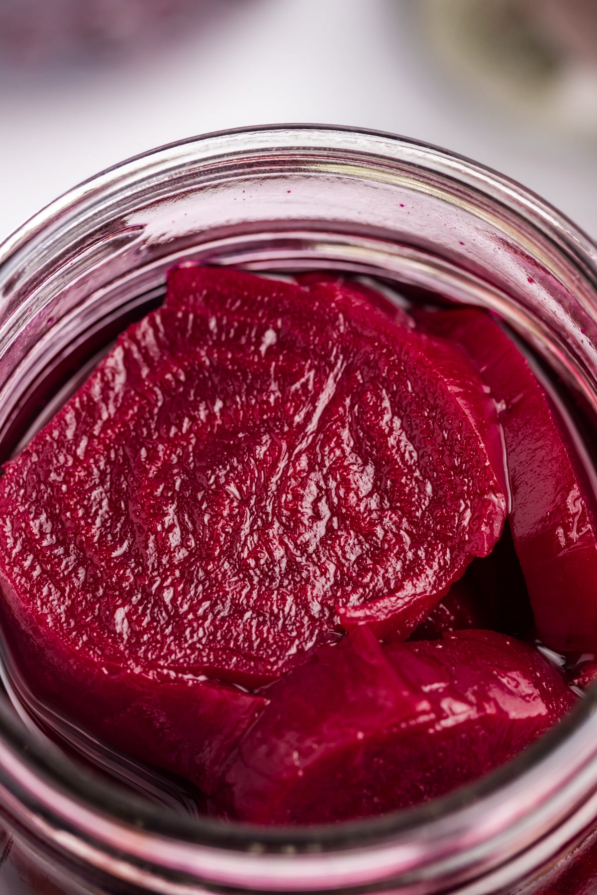 Close-up of an overhead of pickled beets in a jar. 