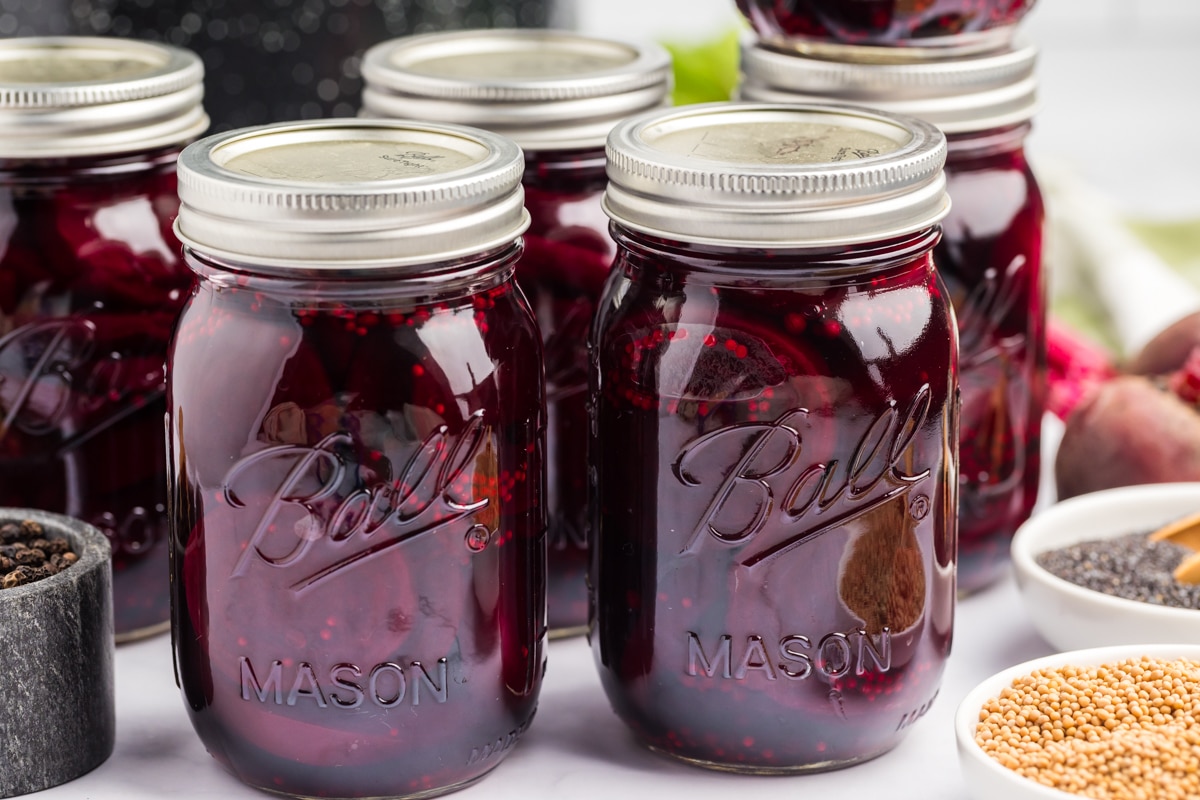 Horizontal photo of jars full of pickled beets. 