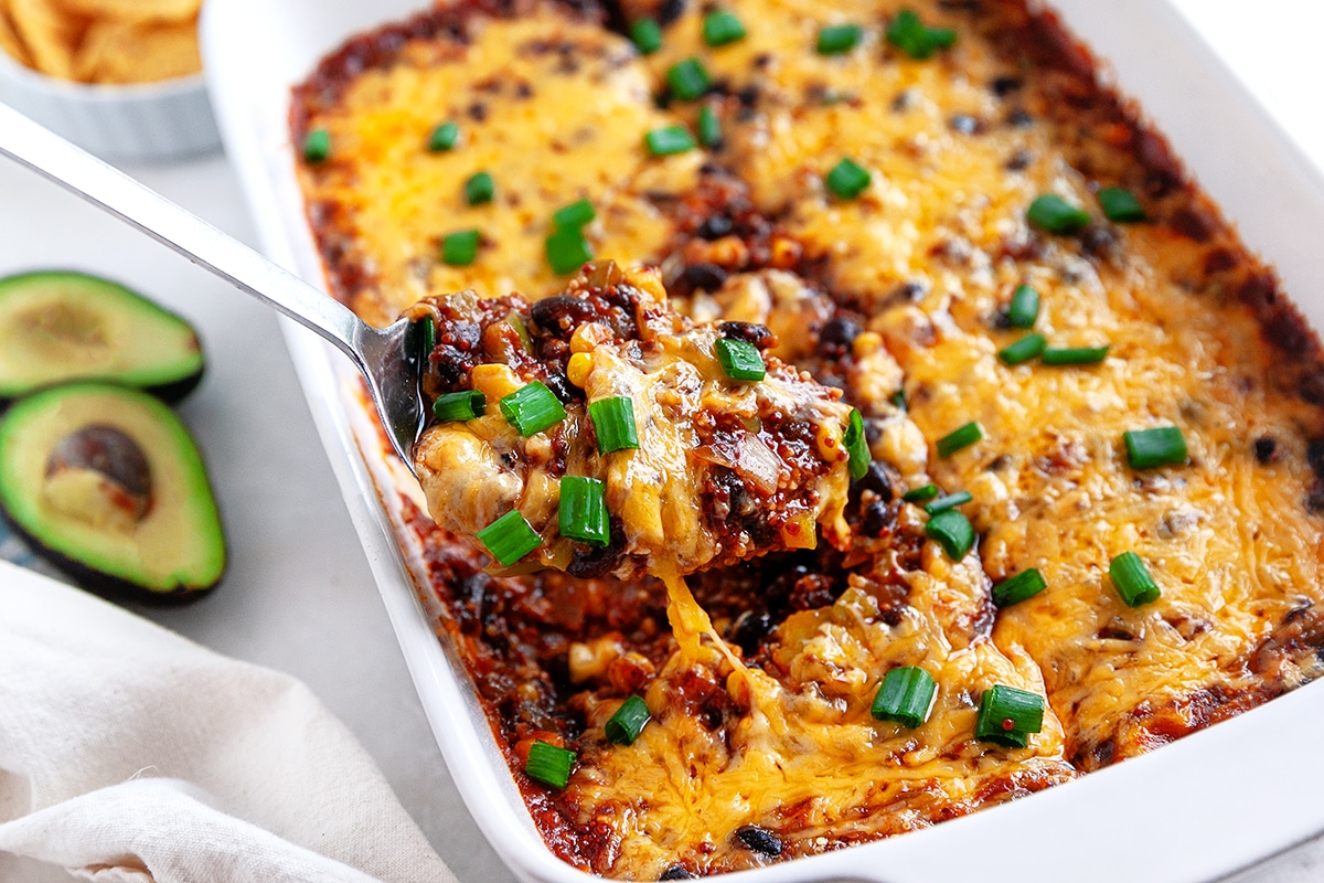 Horizontal photo of scooping out Mexican Casserole. 