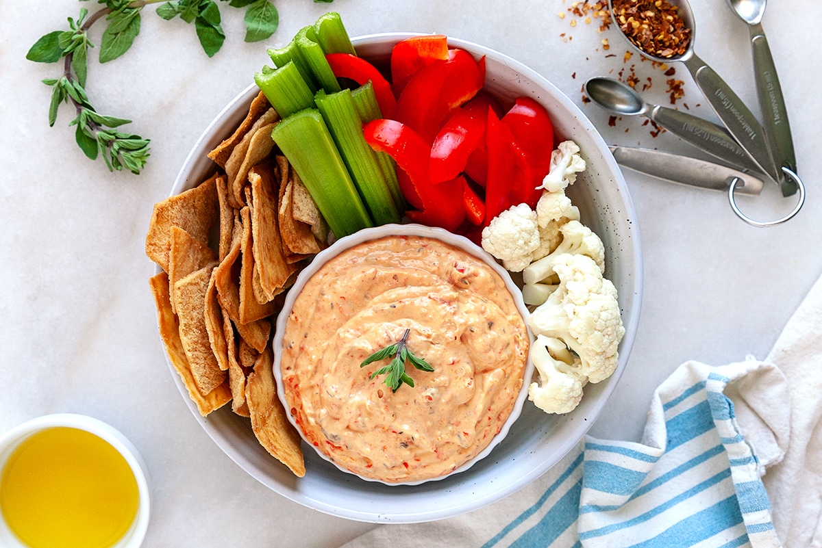 Horizontal picture of dip with veggies and pita chips taken from overhead. 