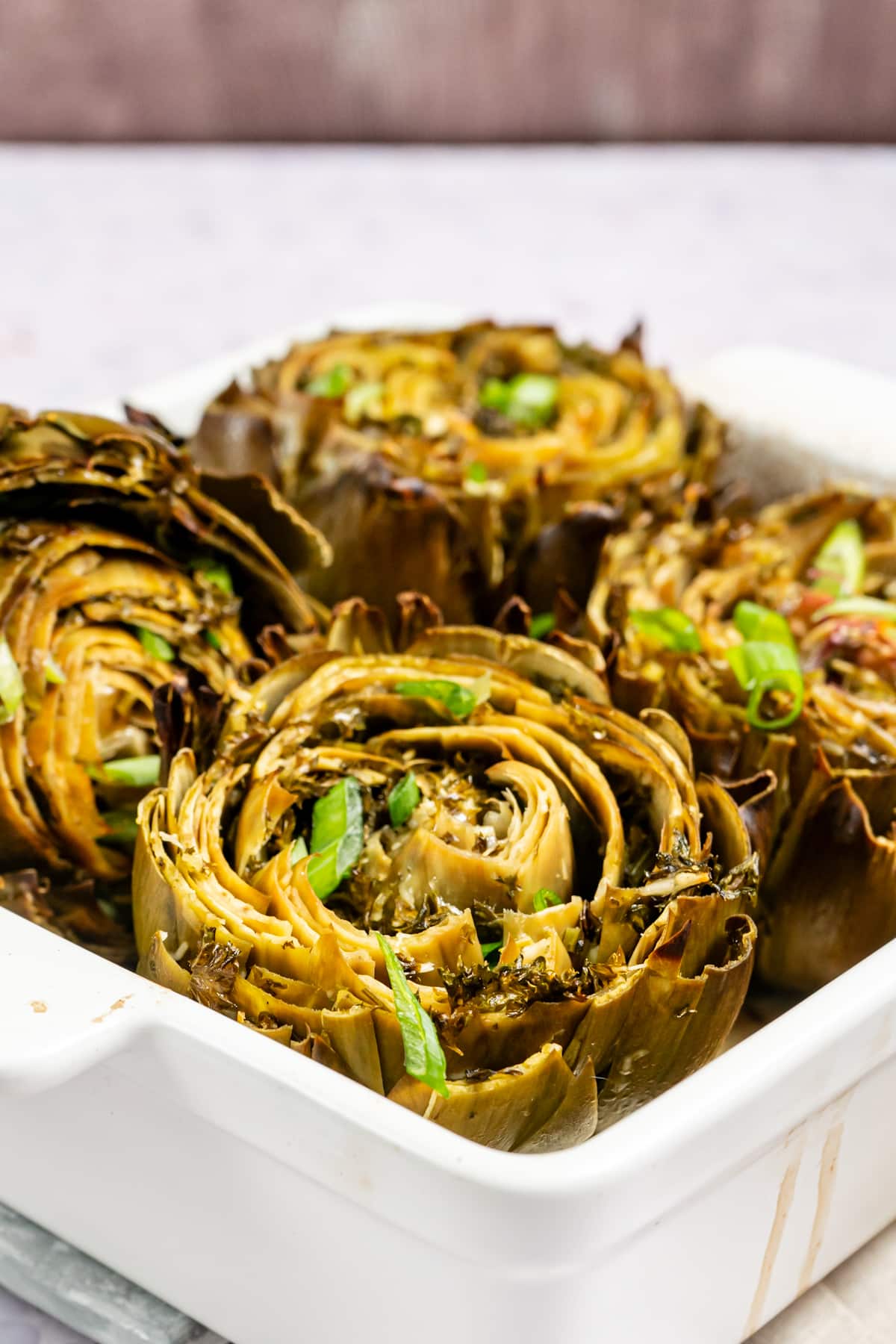 Close up of Stuffed Artichokes in a casserole after baking. 