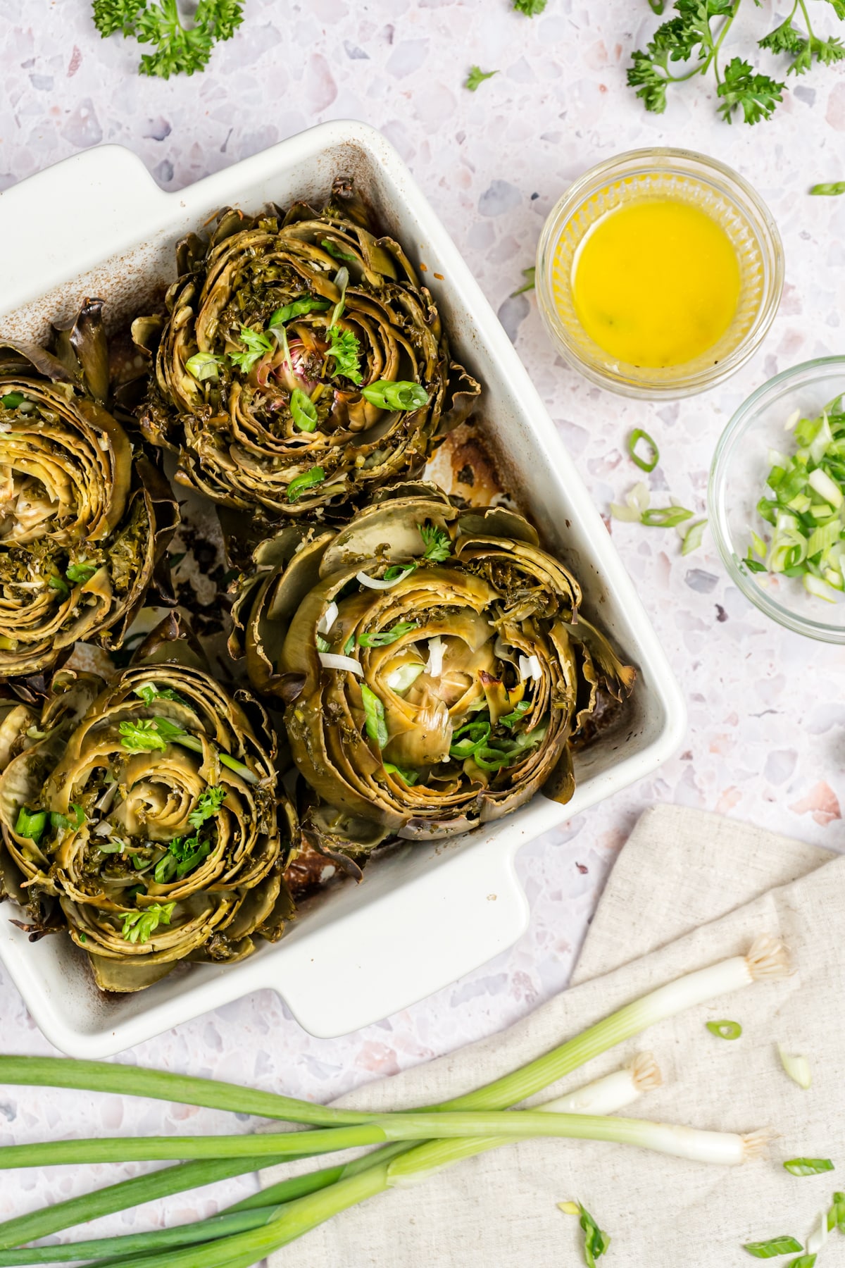 Overhead shot of artichokes in a casserole on an angle. 