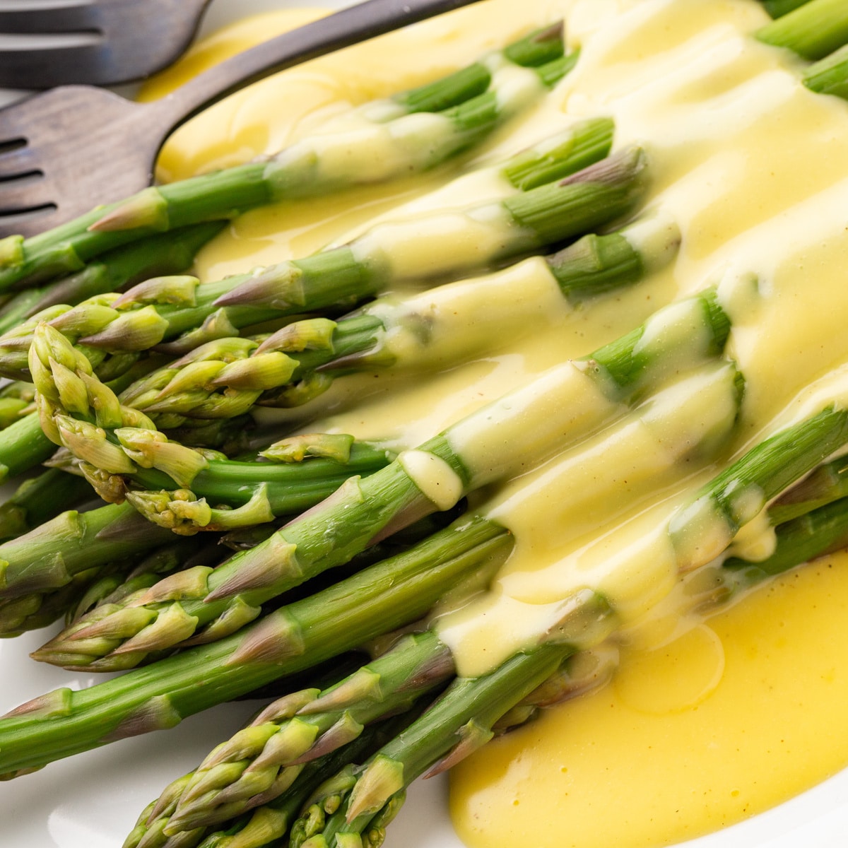 Square photo, close-up of asparagus with hollandaise sauce. 