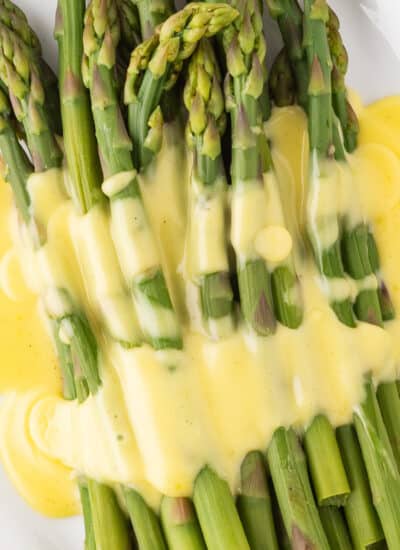 Close=up overhead view of asparagus and hollandaise sauce.