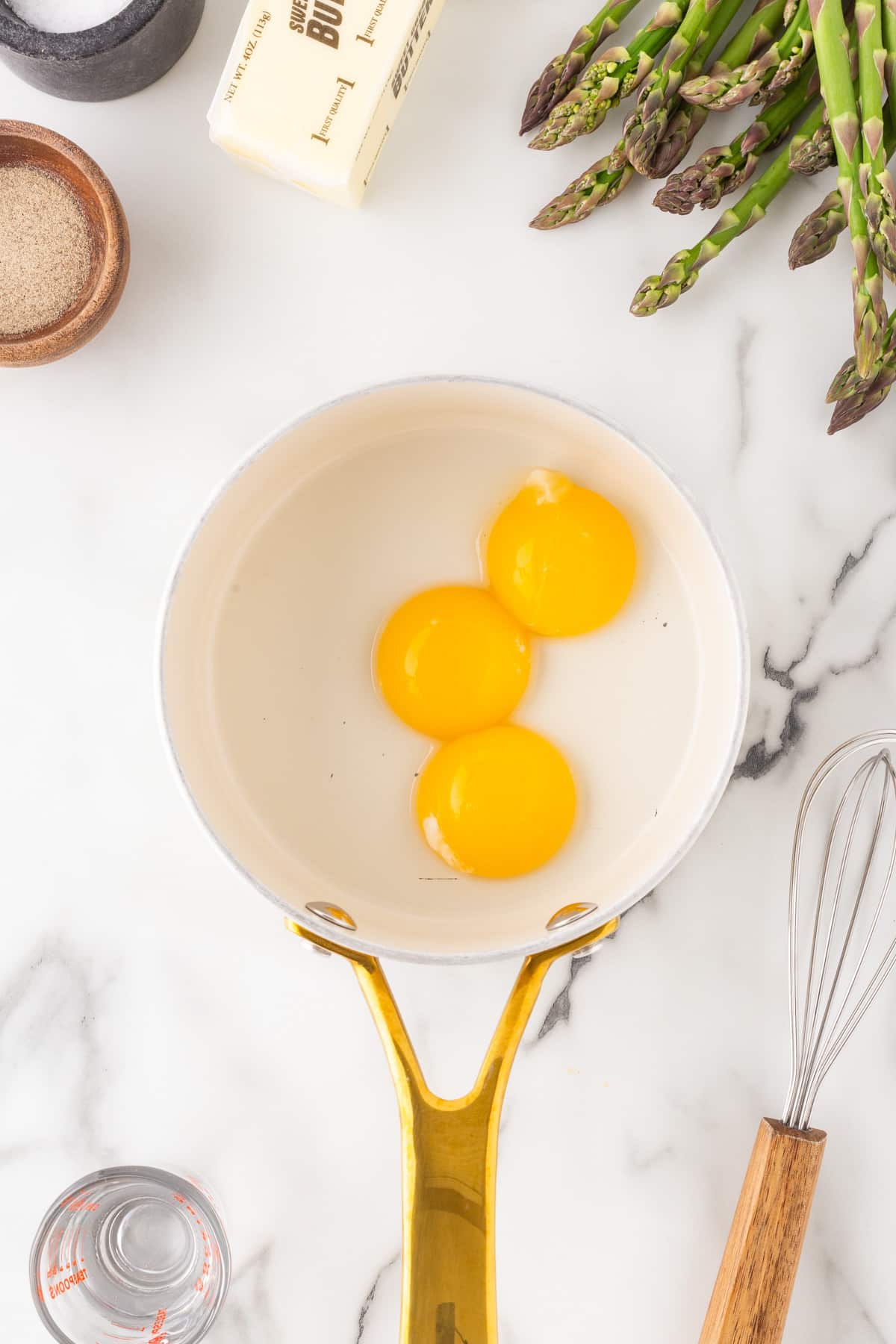 Egg yolks added to a pan. 
