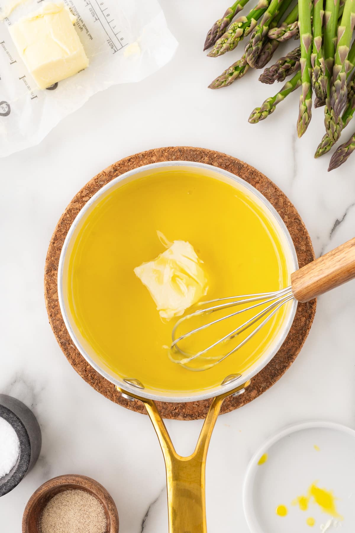 Whisking softened butter into the sauce. 