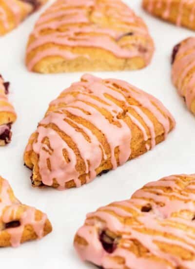 Front view of cherry scones that are drizzled in icing.