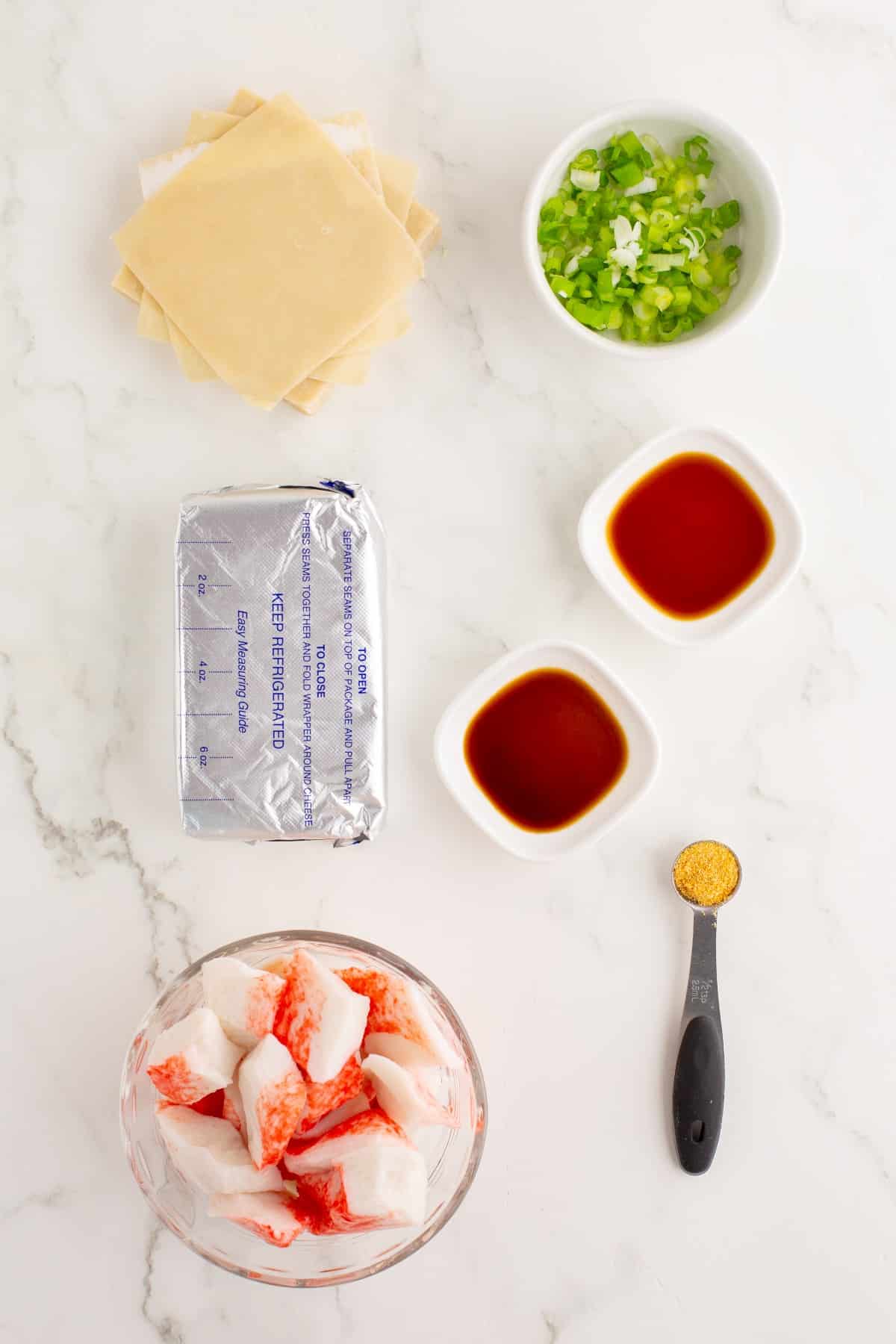 Ingredients to make crab rangoon on a white countertop.