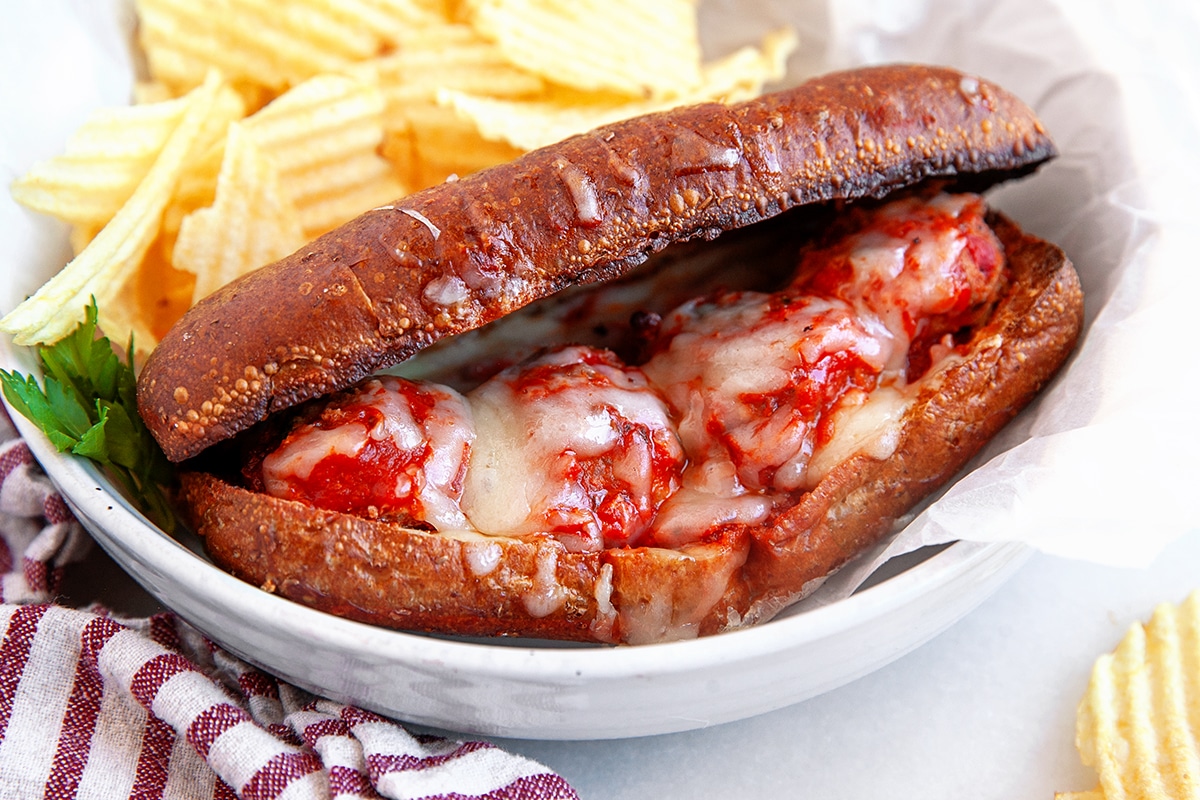 Horizontal picture of a meatball sub with rippled potato chips. 