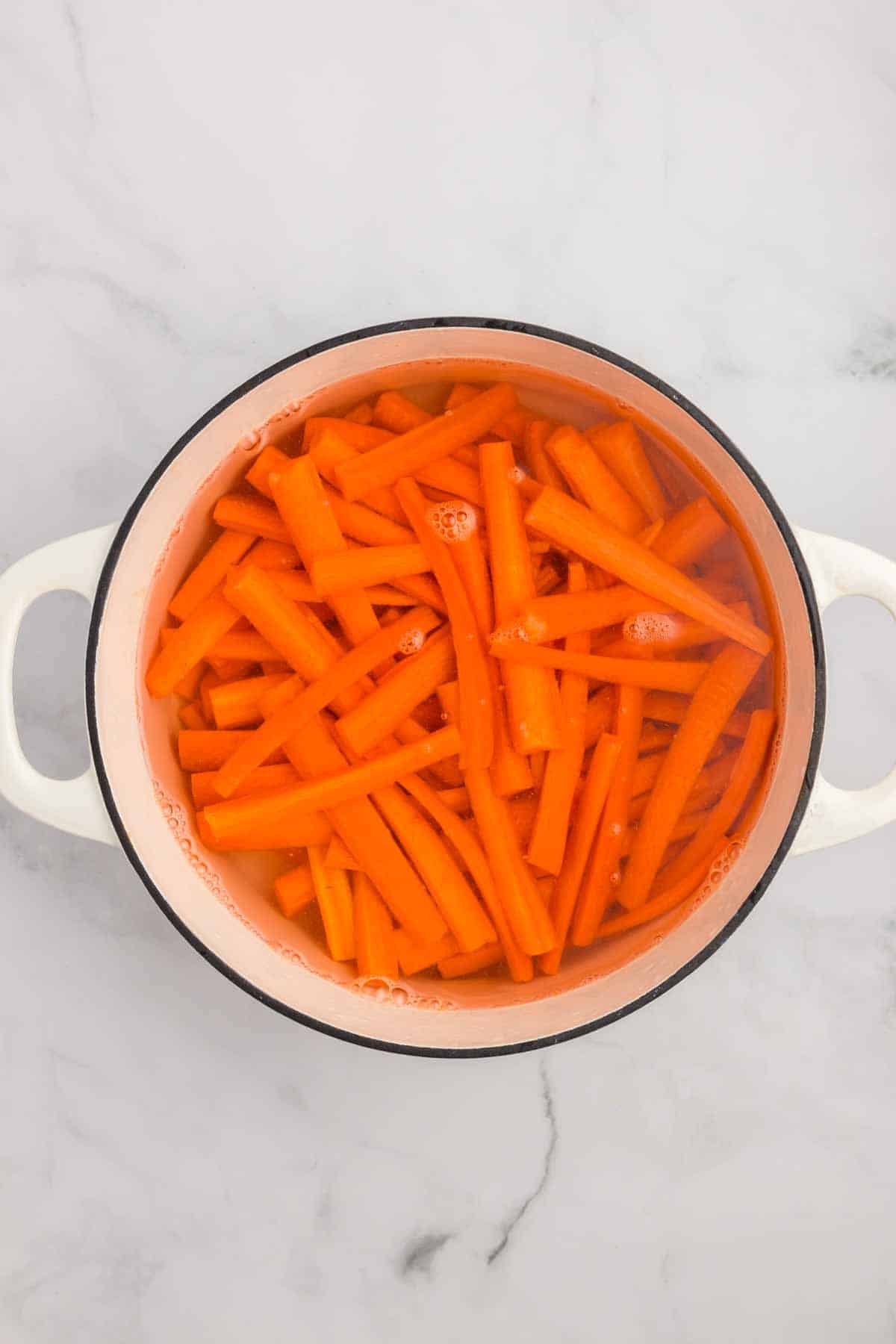 Carrot sticks in a pot of water. 