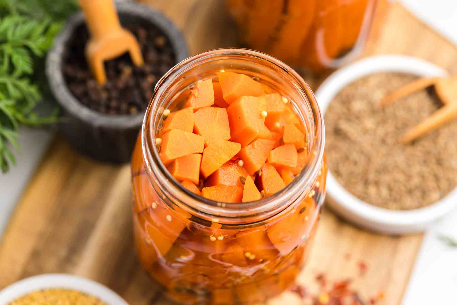 Open jar of pickled carrots from overhead. 