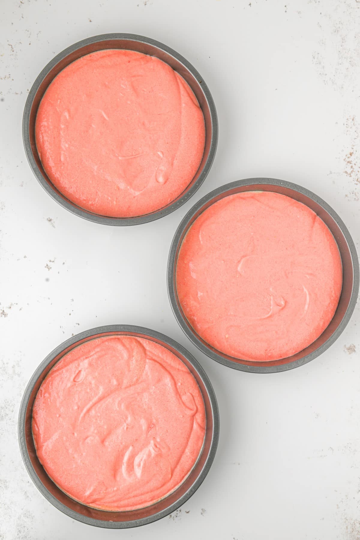 The round cake pans filled with batter. 