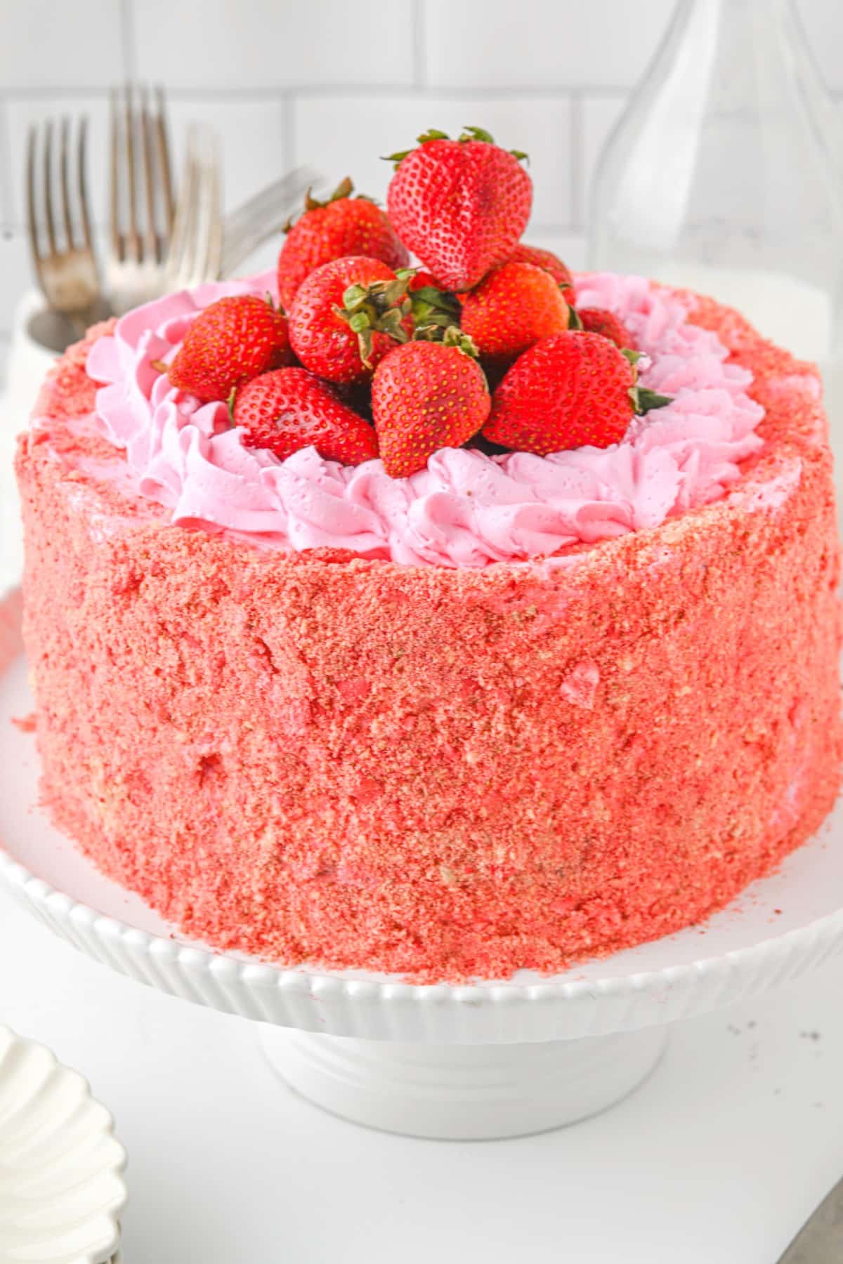 Front view of a Strawberry Crunch Cake on a cake stand. 