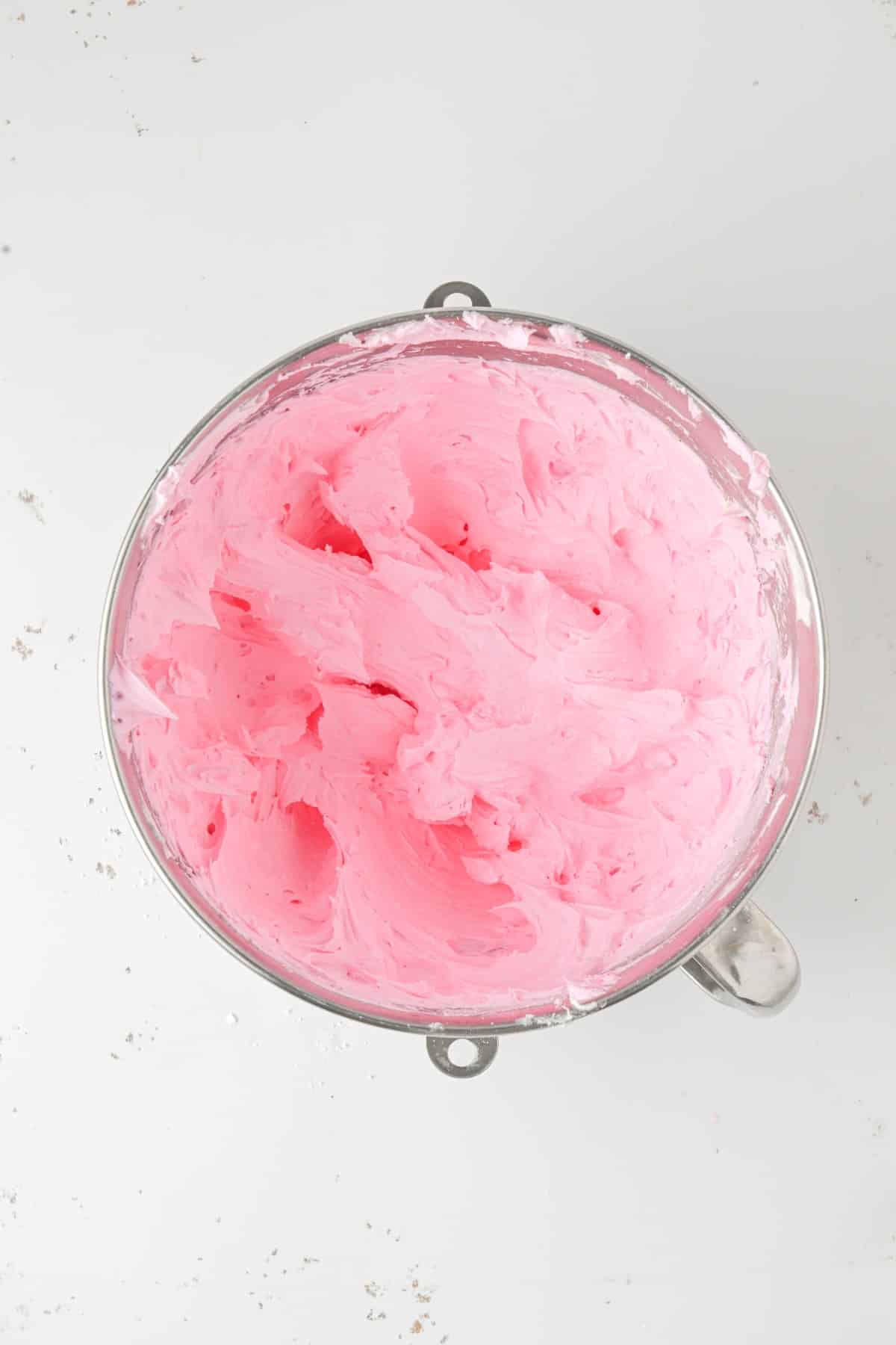 Top view of pink icing in a bowl.. 