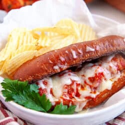 Meatball Sub with ripple chips on a plate.
