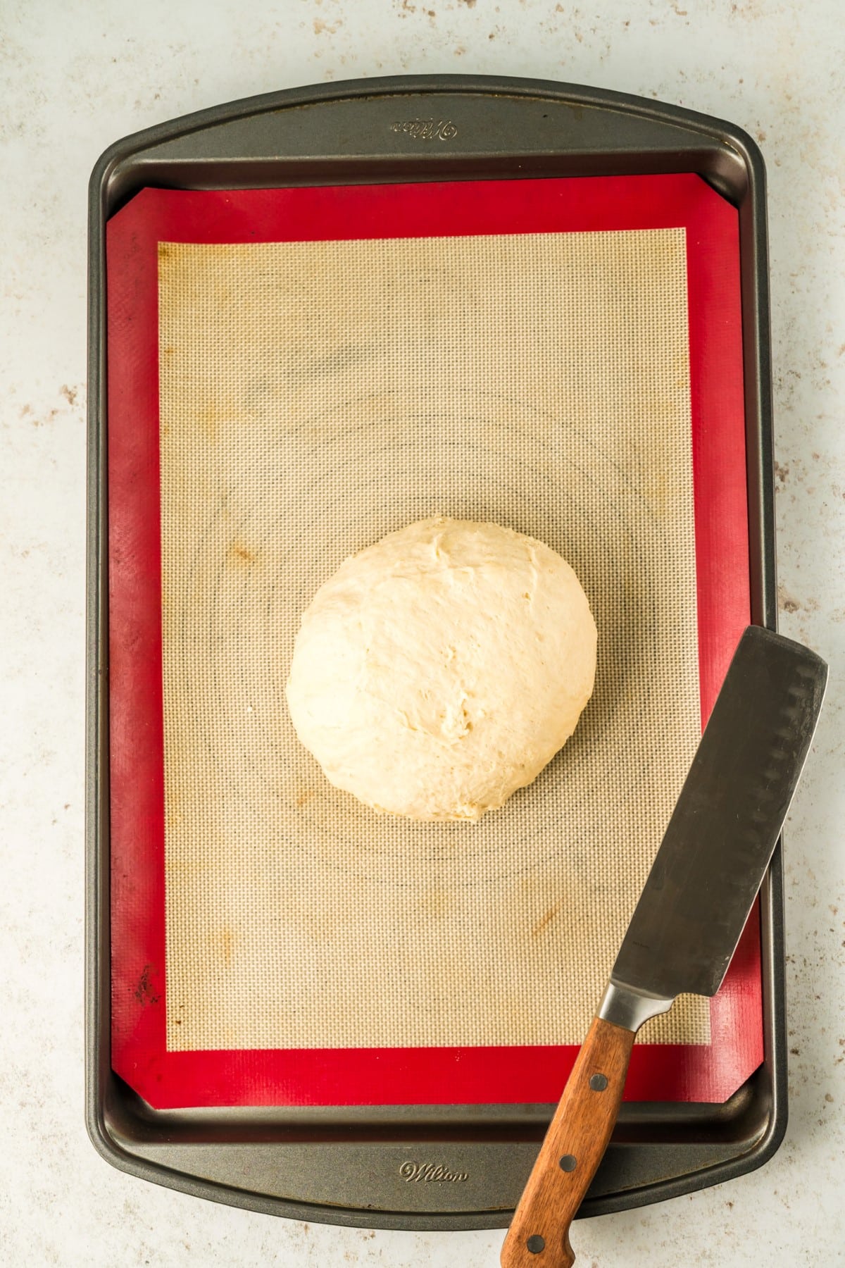 Dough in a ball on a baking mat. 