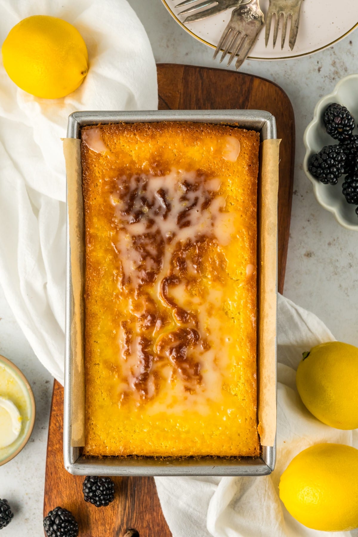 Cake still in the pan with icing drizzled on. 