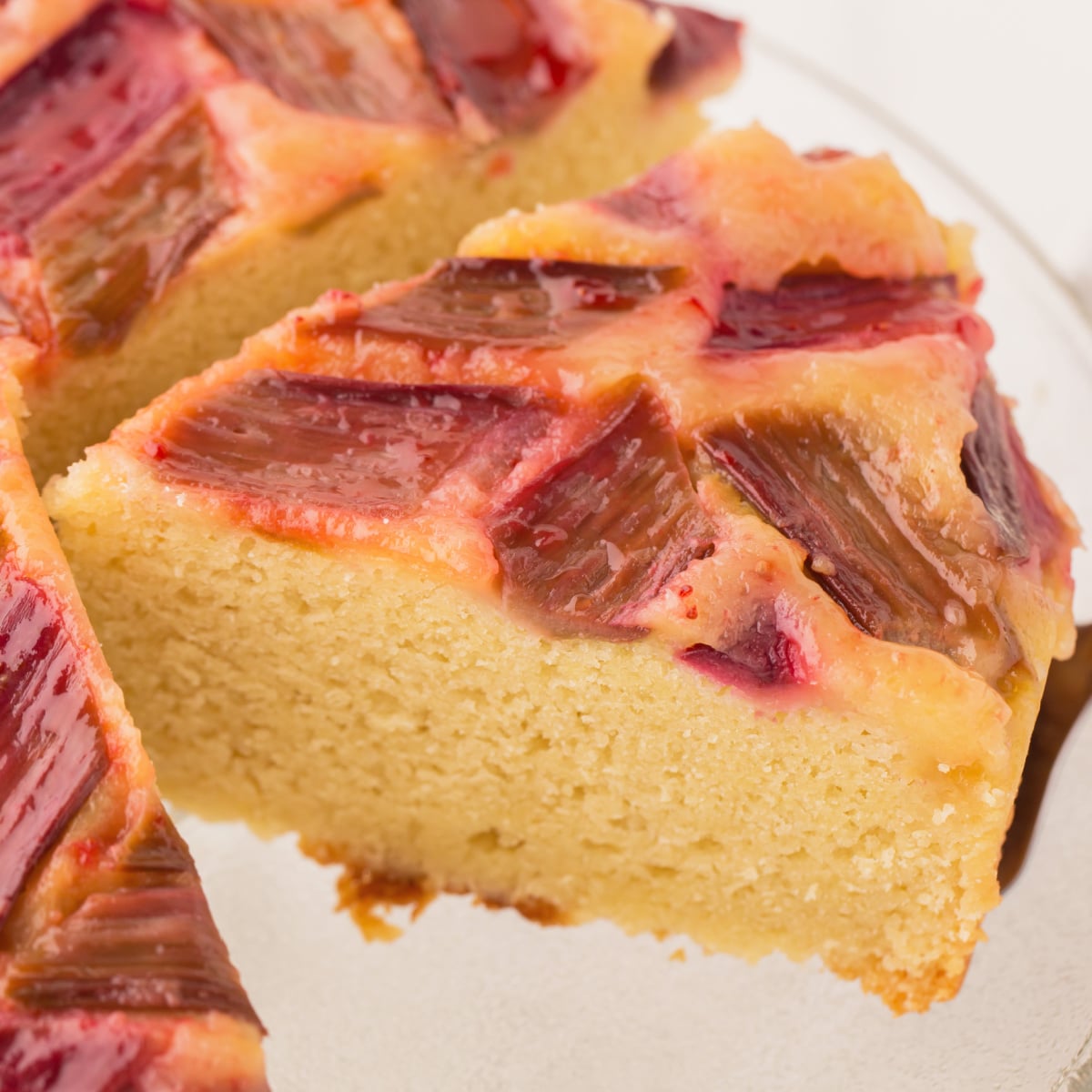 A slice of rhubarb cake being taken from the cake. 