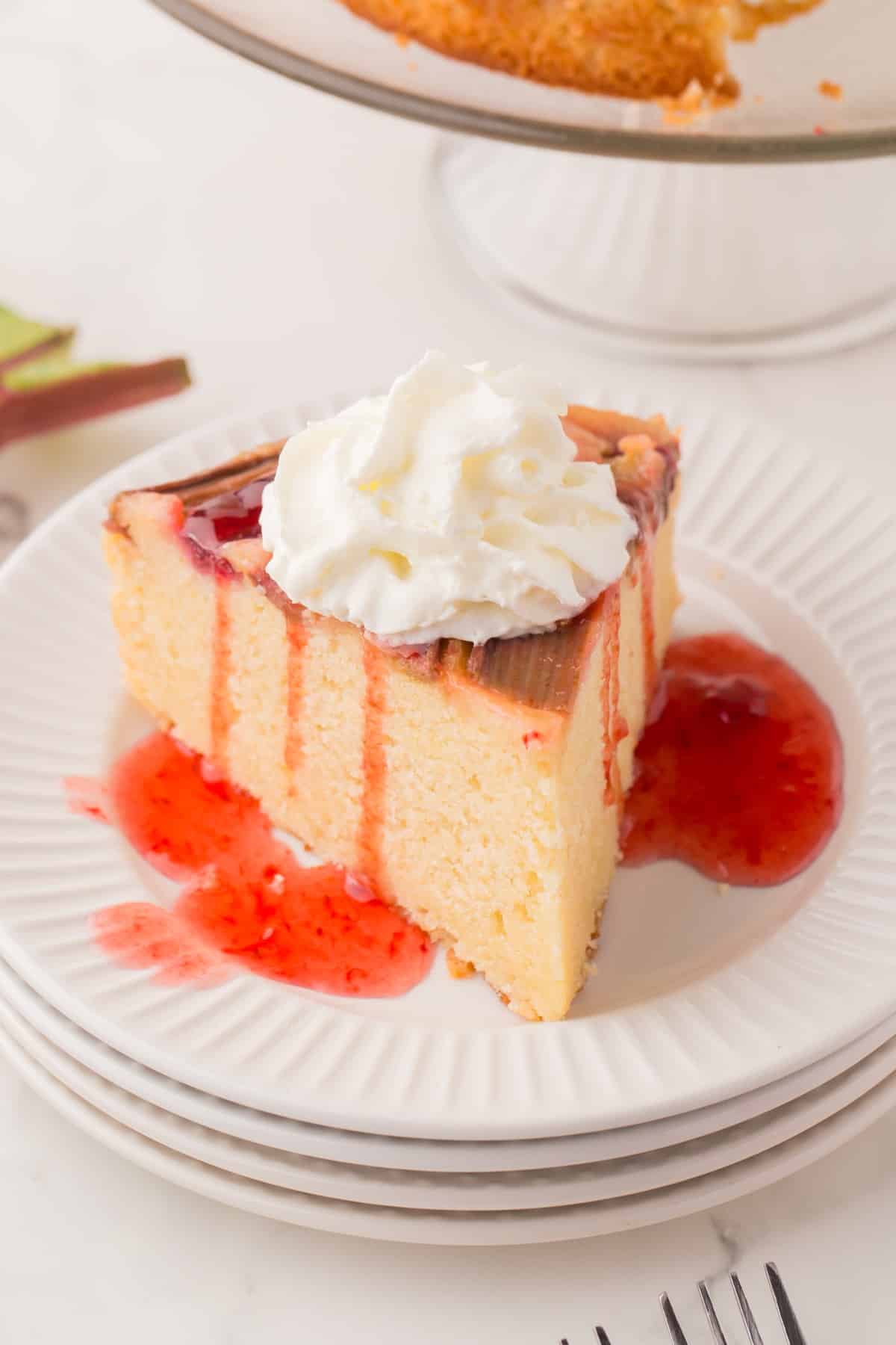 A slice of cake with jam over the top and whipped cream. 
