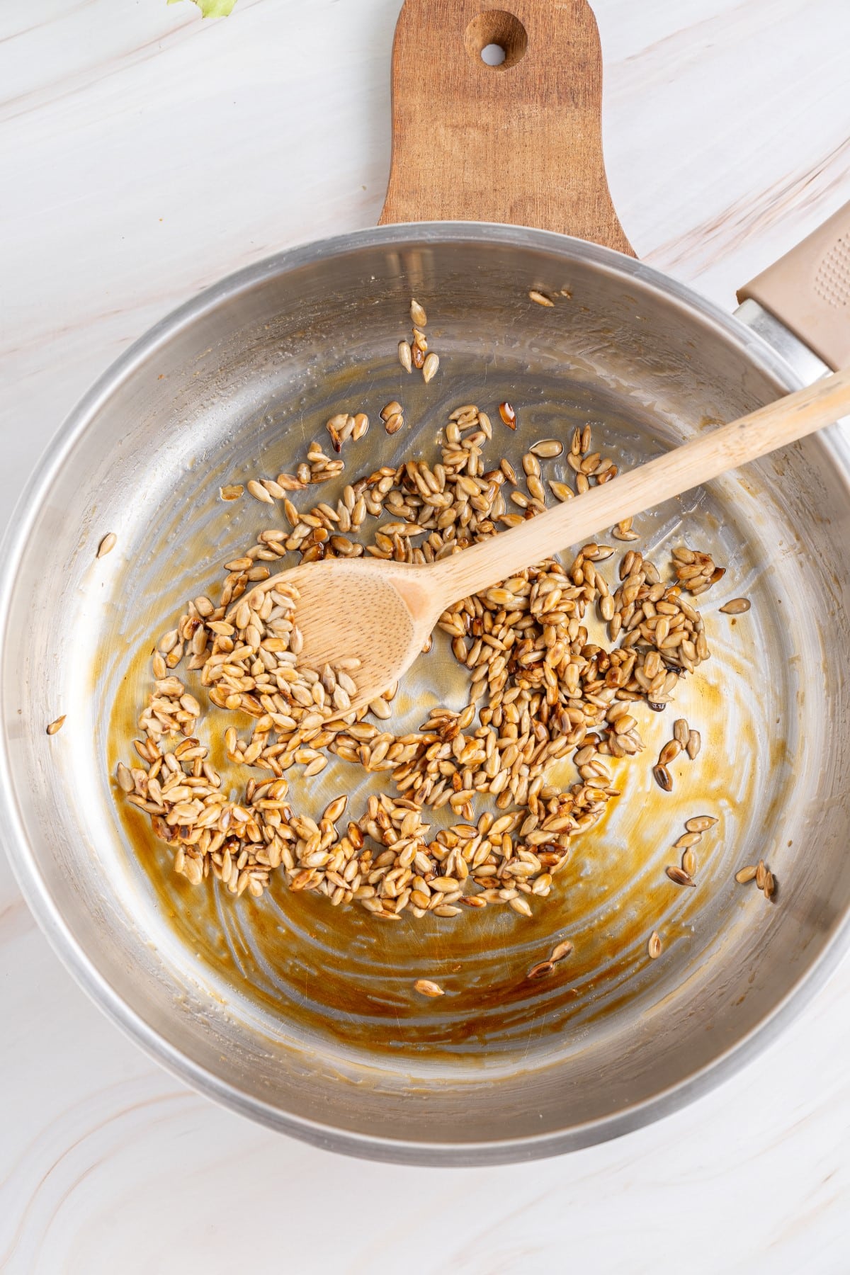 Sunflower seeds and honey in a fry pan. 