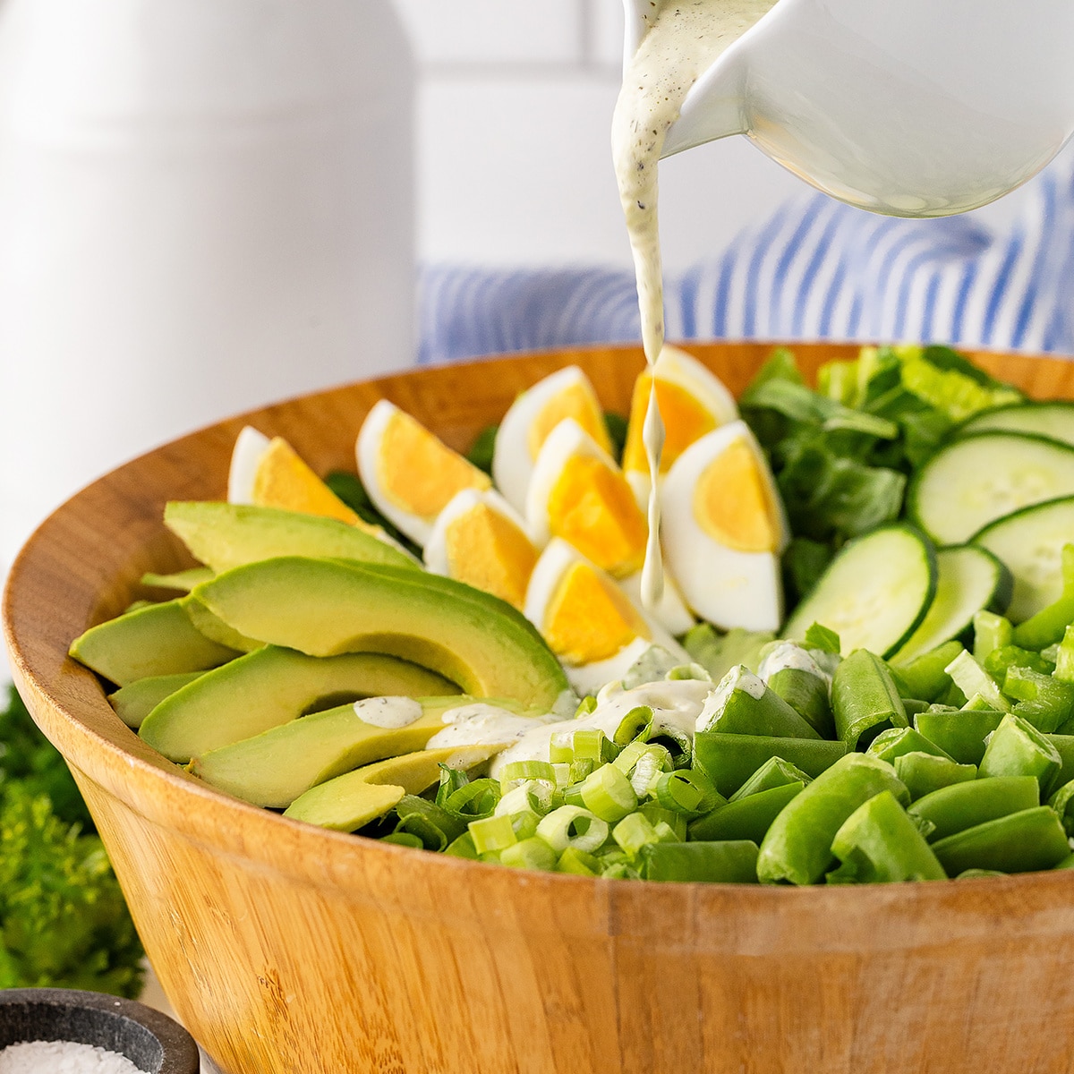 Pouring dressing on the salad. 