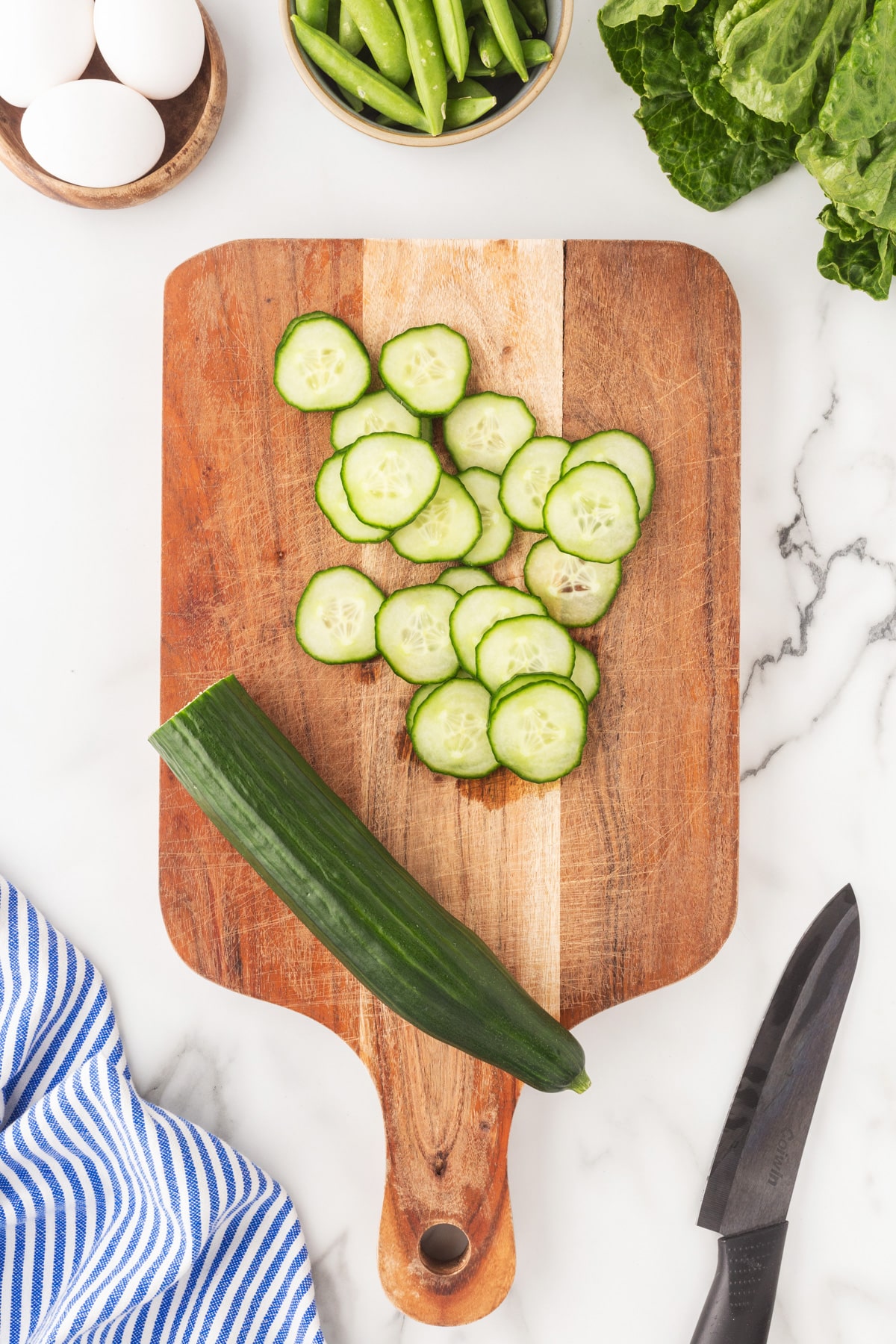 Sliced cucumber on a cutting board.