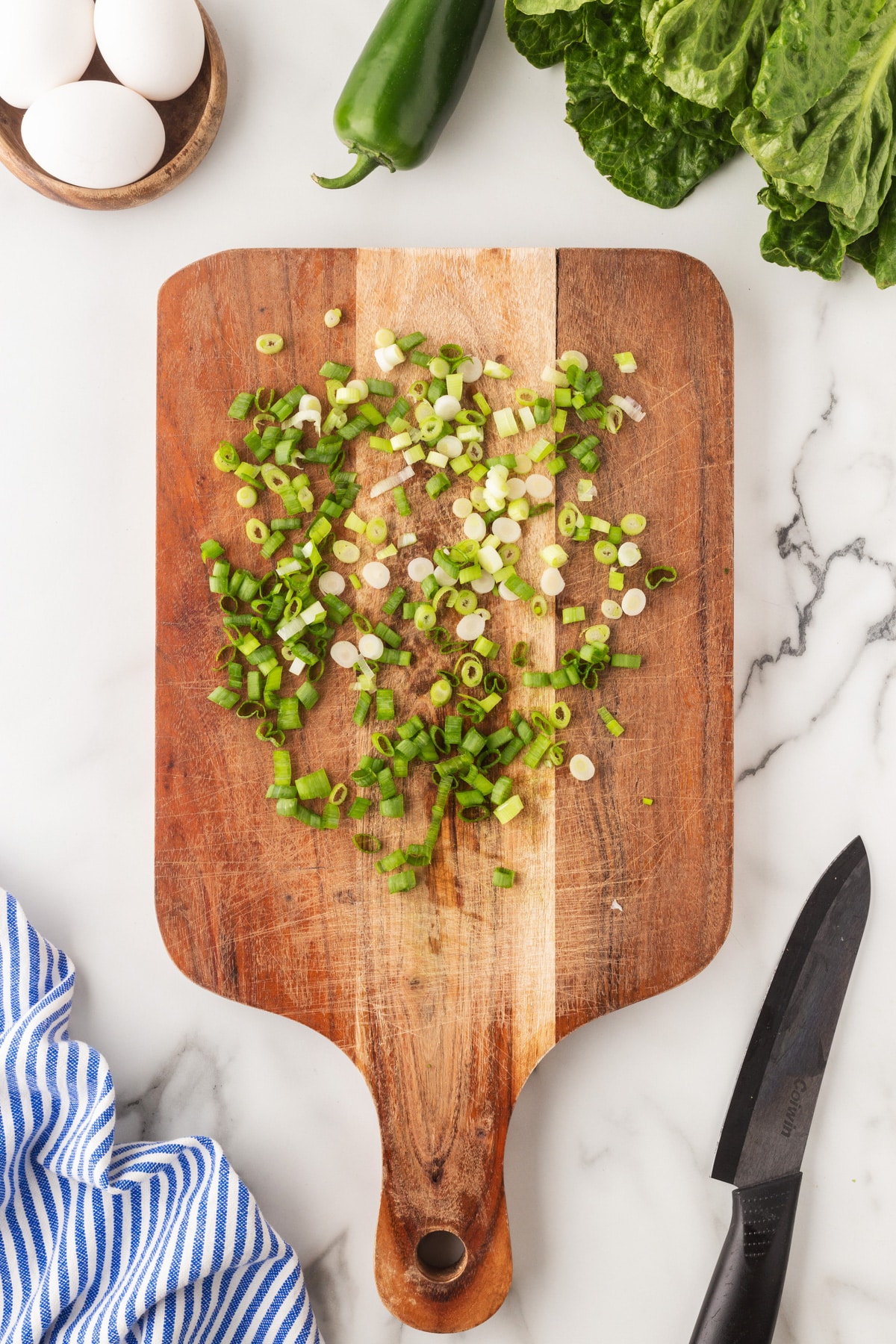 Green onions chopped on a cutting board. 