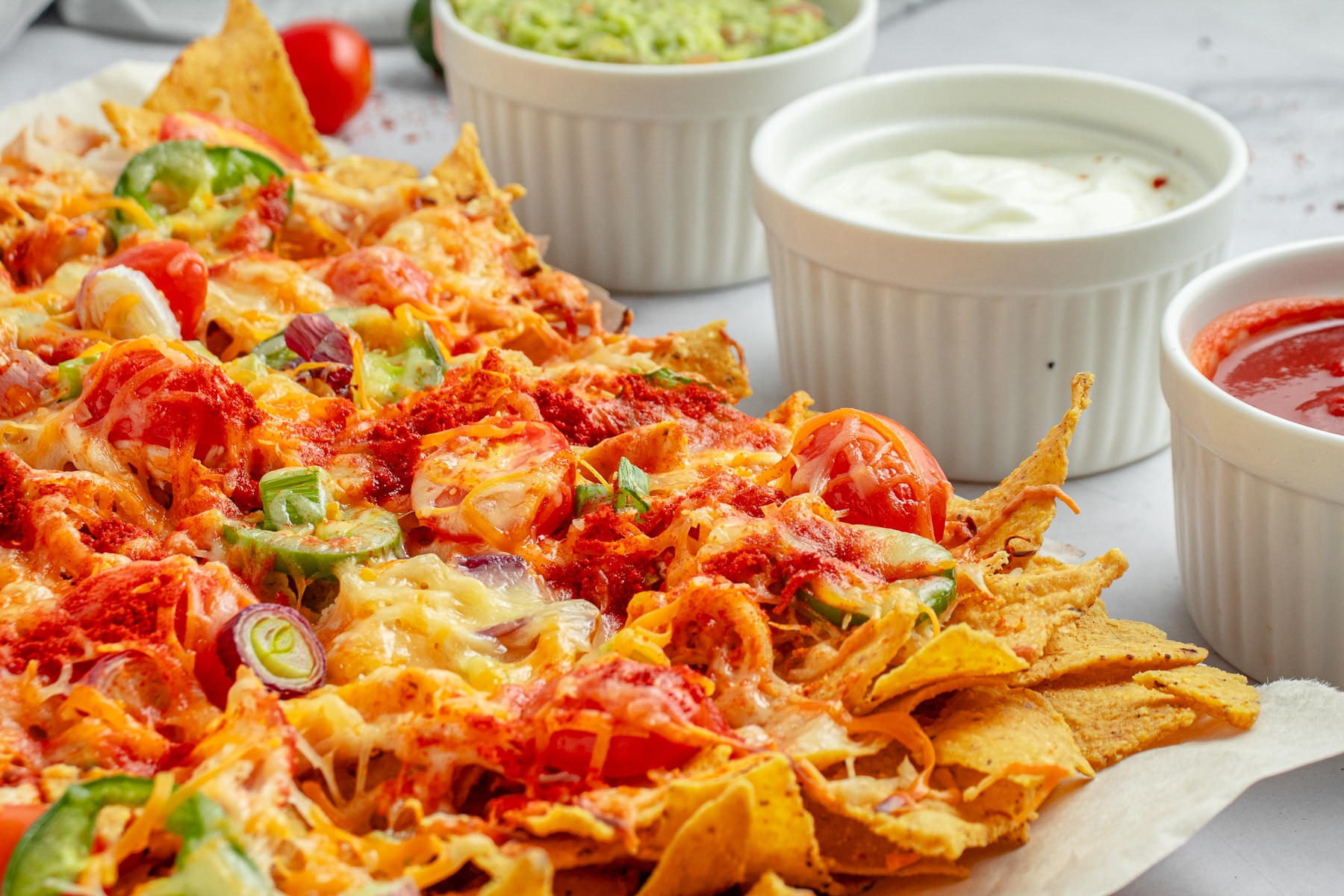 Baked Chicken Nachos served with sour cream, guacamole and salsa. Horizontal shot.. 