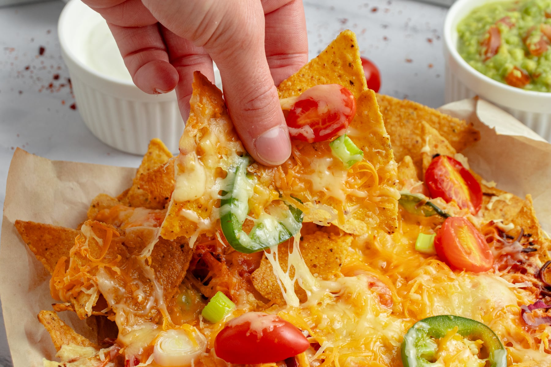 Grabbing nachos in a horizontal picture. 