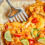 Taking nachos off the pan with a spatula.