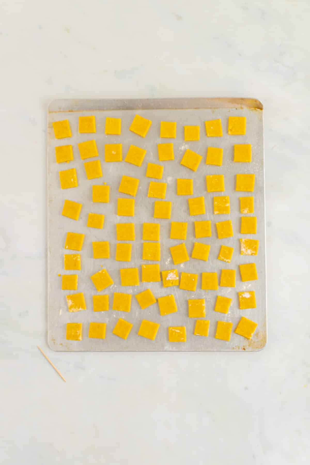 Cheez-Its on a baking sheet ready for the oven. 