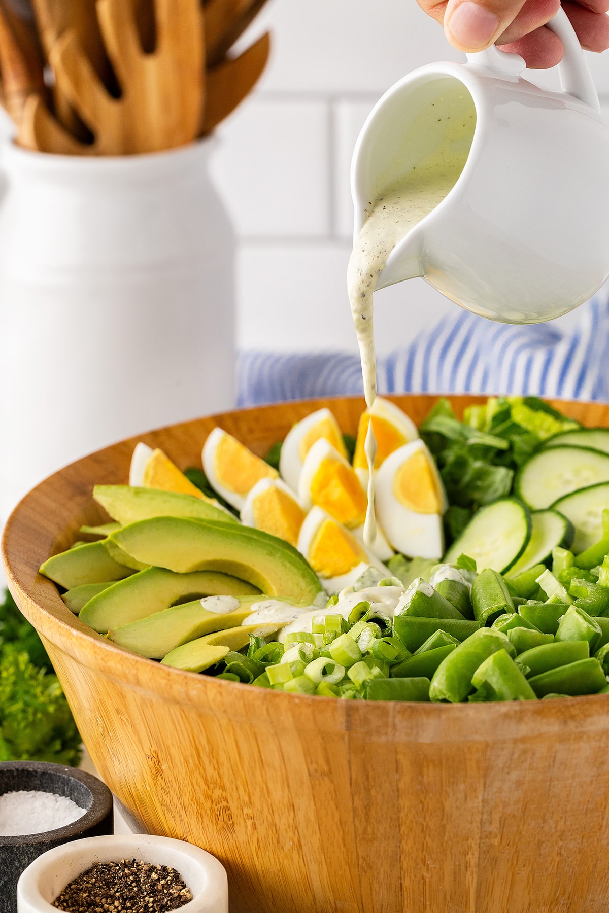 Pouring salad dressing on the salad. 