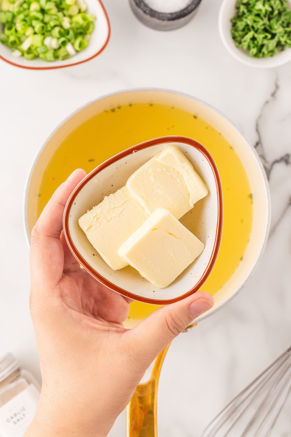 Adding butter to the chicken broth. 