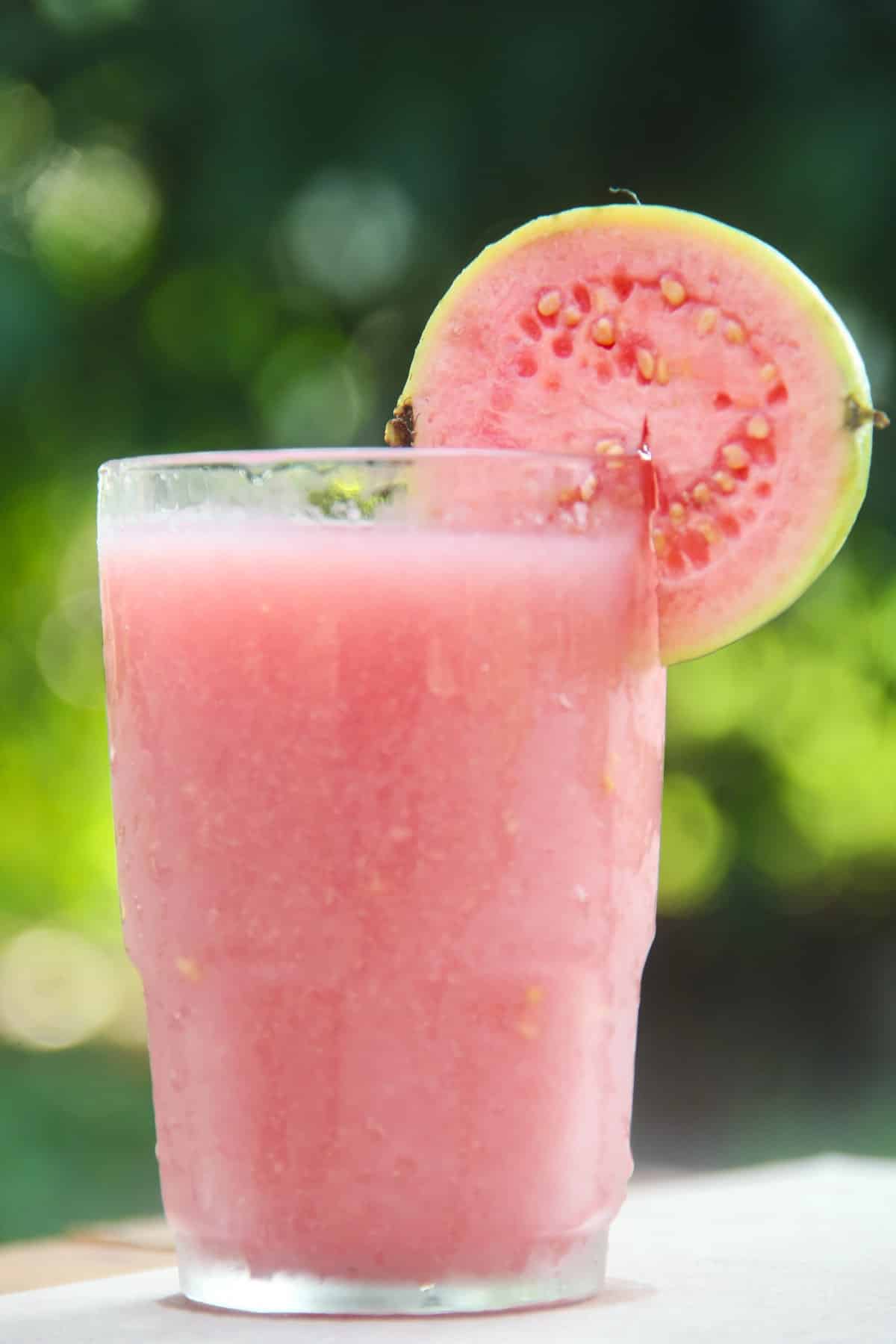 Guava juice with a slice of guava on the glass. 