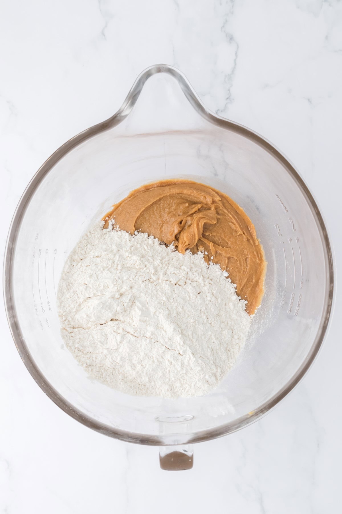 Adding dry ingredients to the peanut butter mixture. 