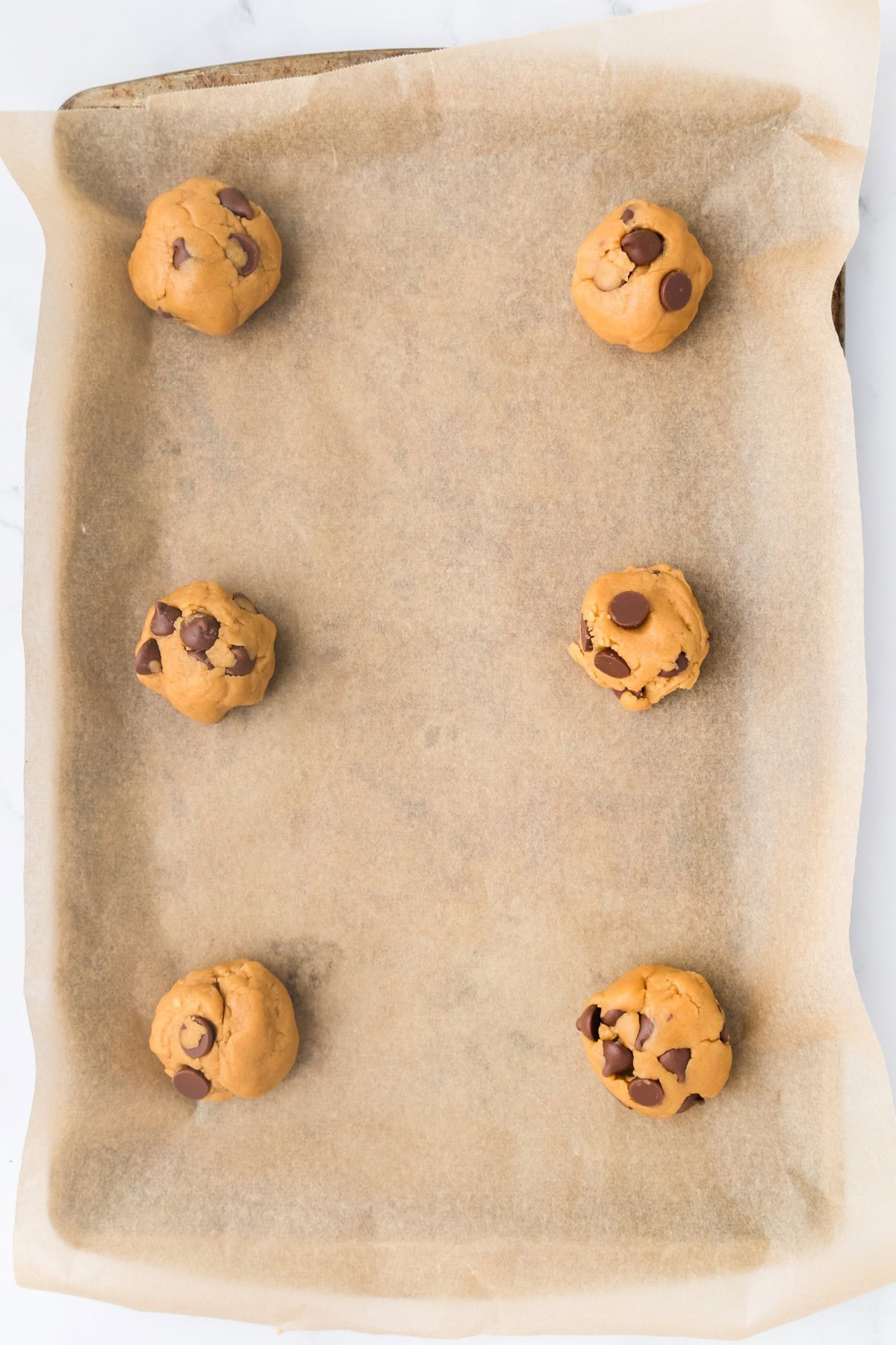 Unbaked cookies on a baking sheet with parchment. 