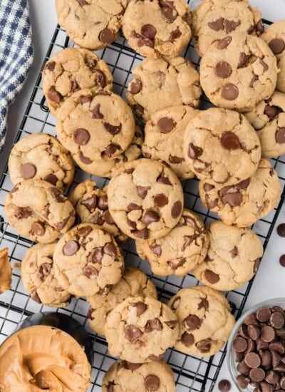 Peanut Butter Chocolate Chip Cookies piled on each other on cooling racks..