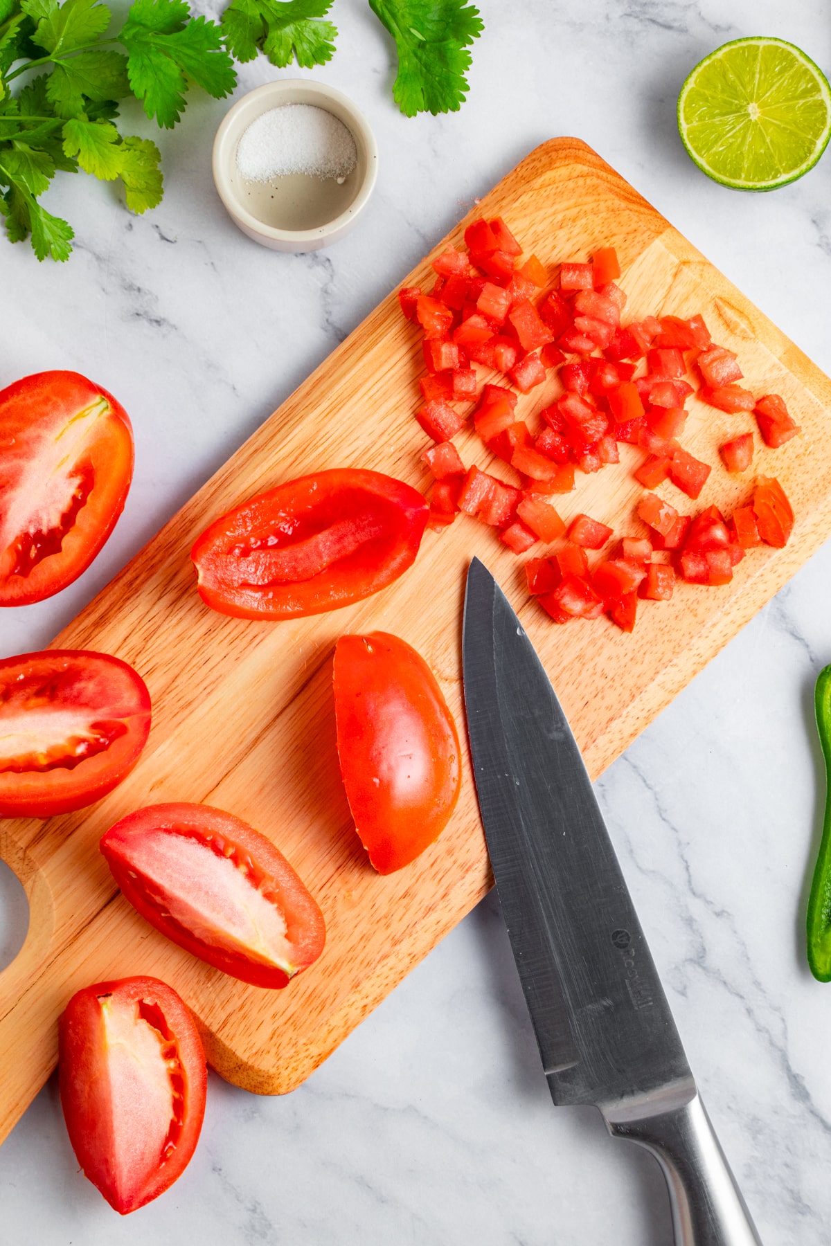 Chopping tomatoes on a chopping board.