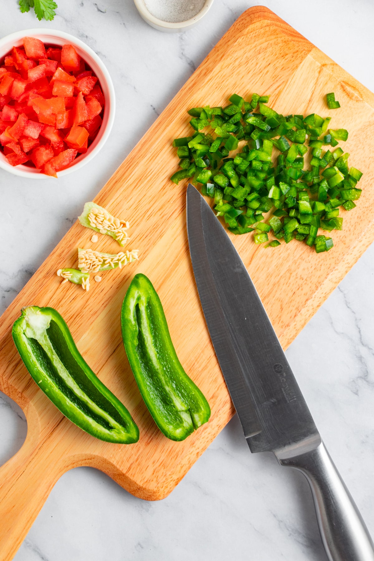 Chopping jalapenos on a chopping board.